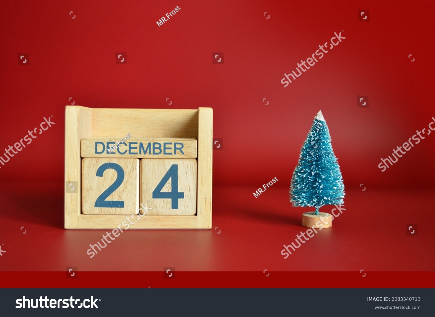 December 24, Calendar design with Christmas tree on red table background. #2083340713