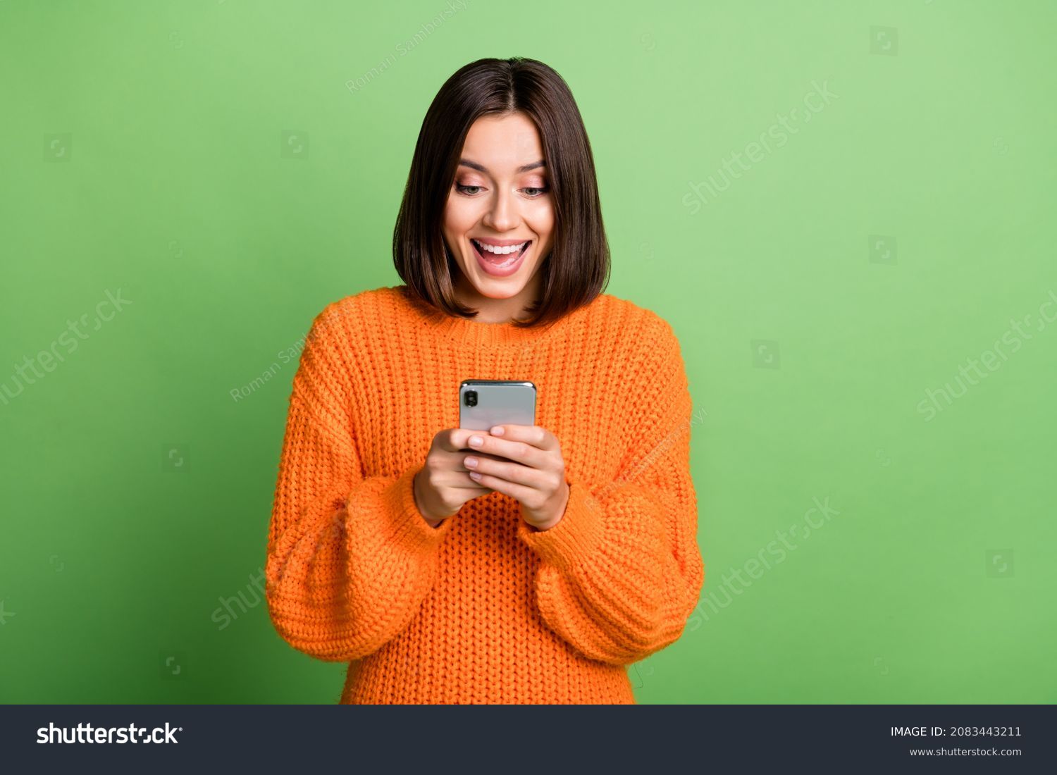 Portrait of attractive cheerful amazed girl using device gadget app smm post isolated over bright green color background #2083443211