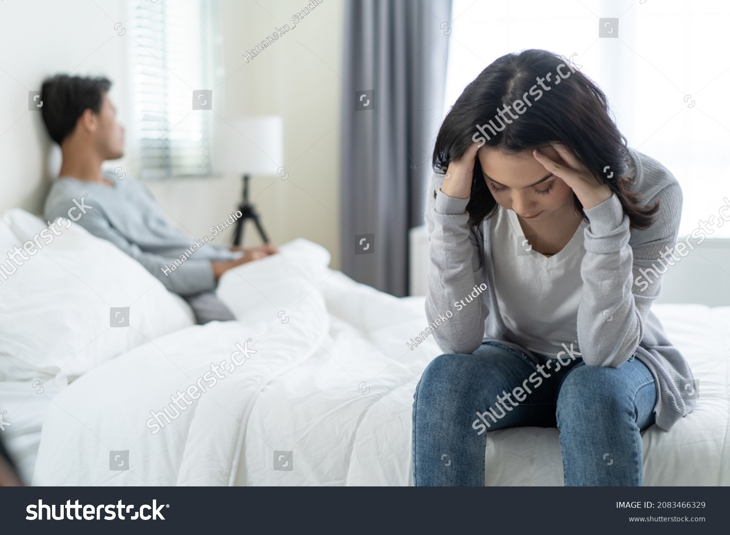 Asian young girl feel angry boyfriend having conflict domestic problem. New marriage man and woman feel heartbroken for quarrel conflict while sit on bed in bedroom. Family problem-separation concept. #2083466329