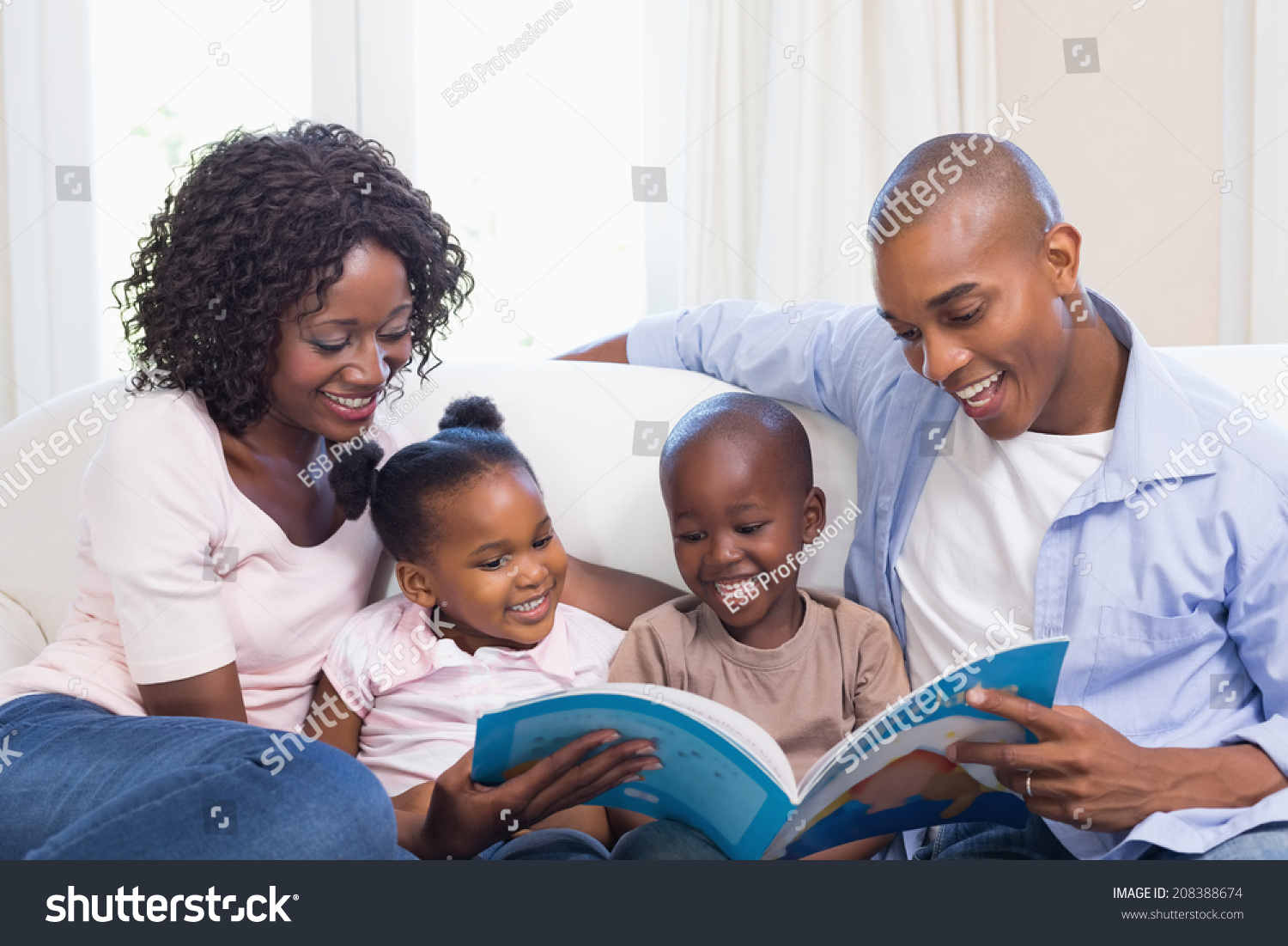 Happy family on the couch reading storybook at home in the living room #208388674