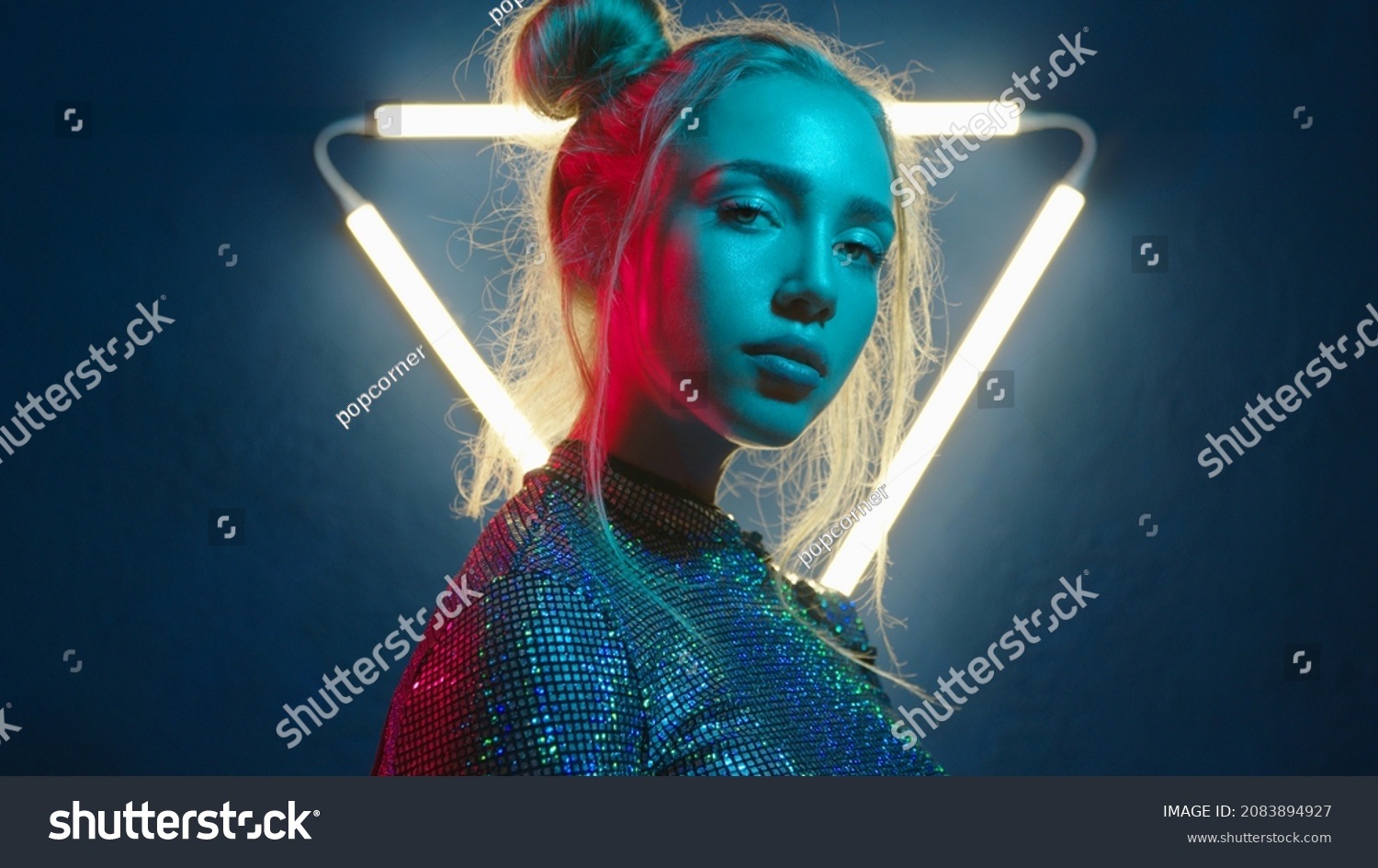 Young woman looking at the camera in the neon light of the club. Camera zoom. Portrait of a beautiful futuristic girl close-up. Lady in multicolor glow. #2083894927