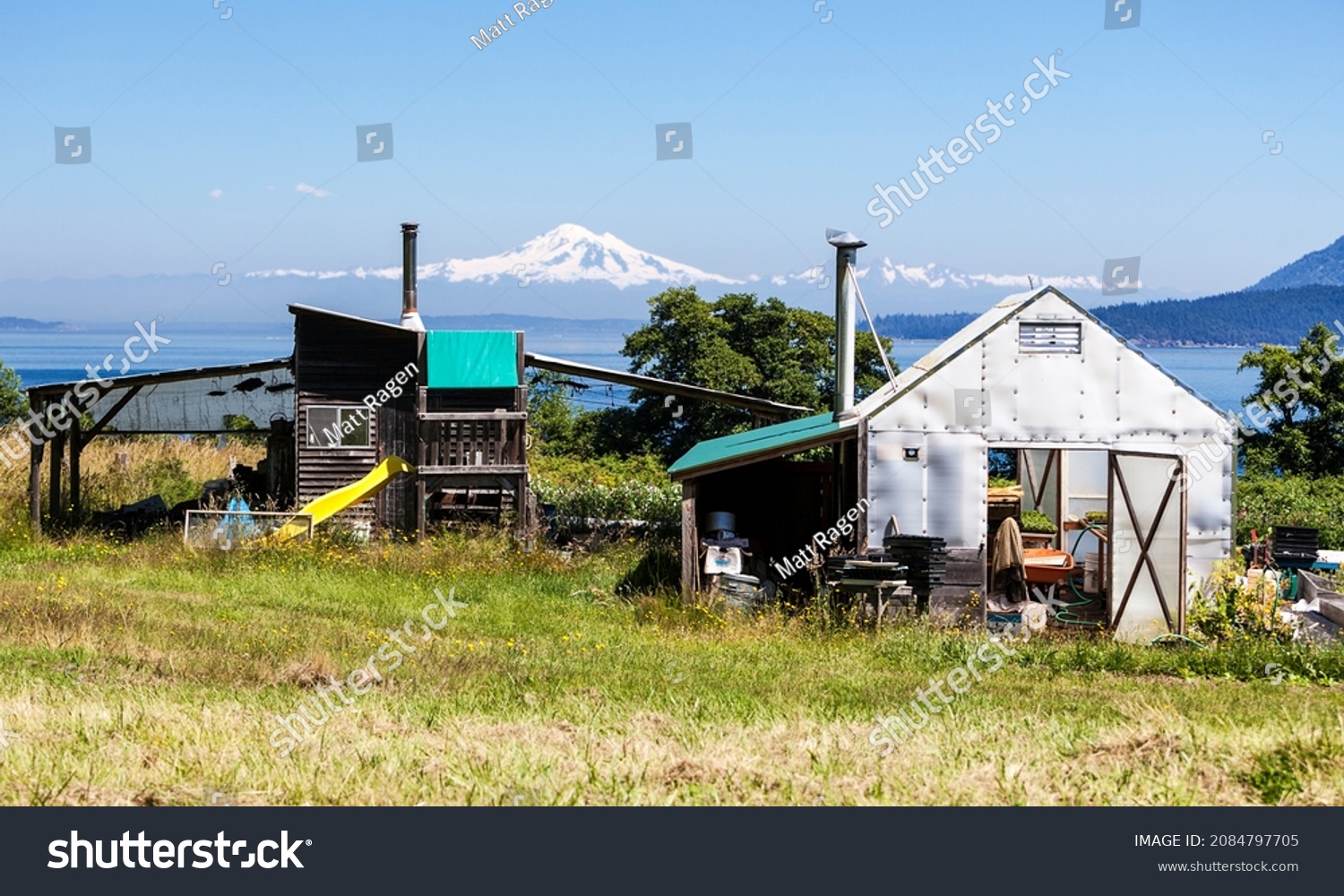 Two small outbuildings on a small organic farm on Waldron Island in Washington State. Mt. Baker is visible in the background. #2084797705
