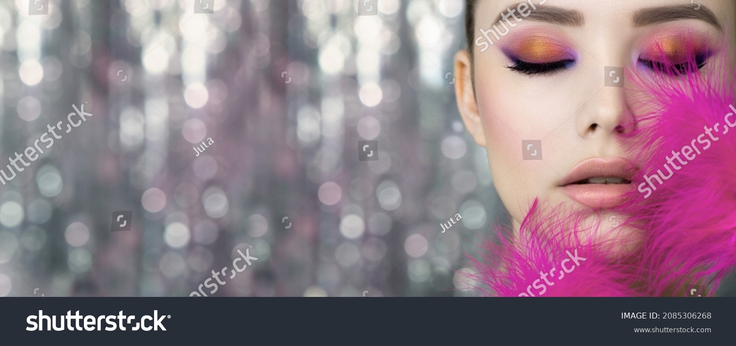 Portrait of beauty model with bright color makeup. Face of beautiful young woman with professional make up  and vivd pink feathers. Close up, selective focus. #2085306268
