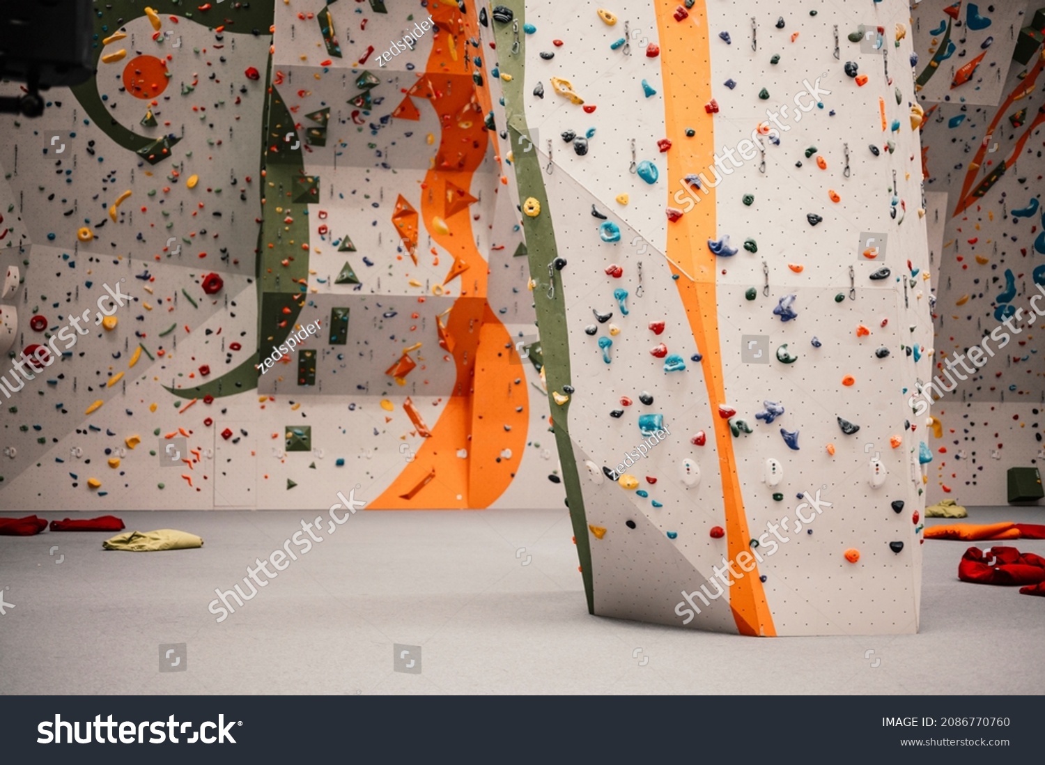 Climber wearing in climbing equipment. Practicing rock-climbing on a rock wall indoors. Xtreme sports and bouldering concept. #2086770760