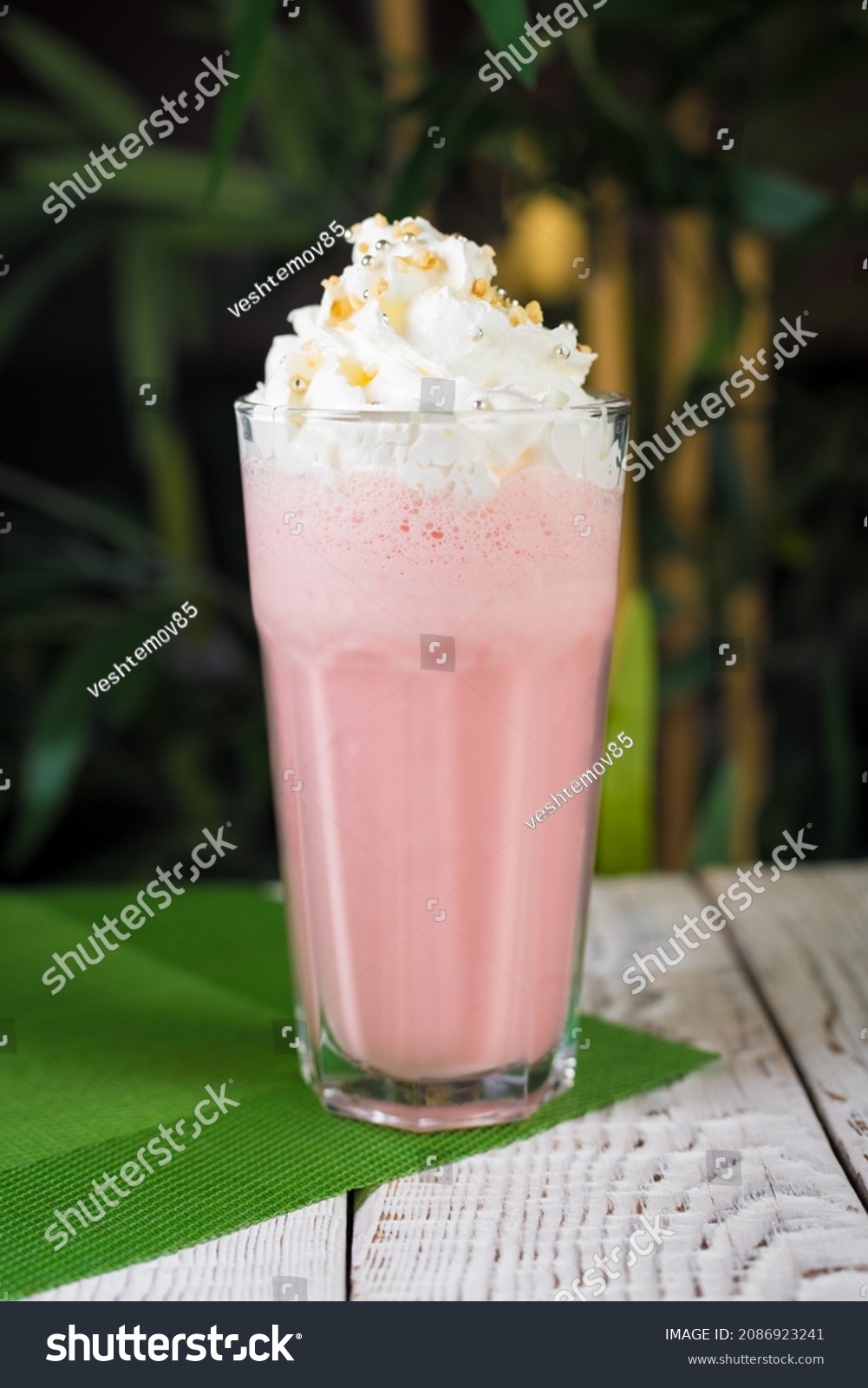 A glass of healthy strawberry smoothie with whipping cream on top #2086923241