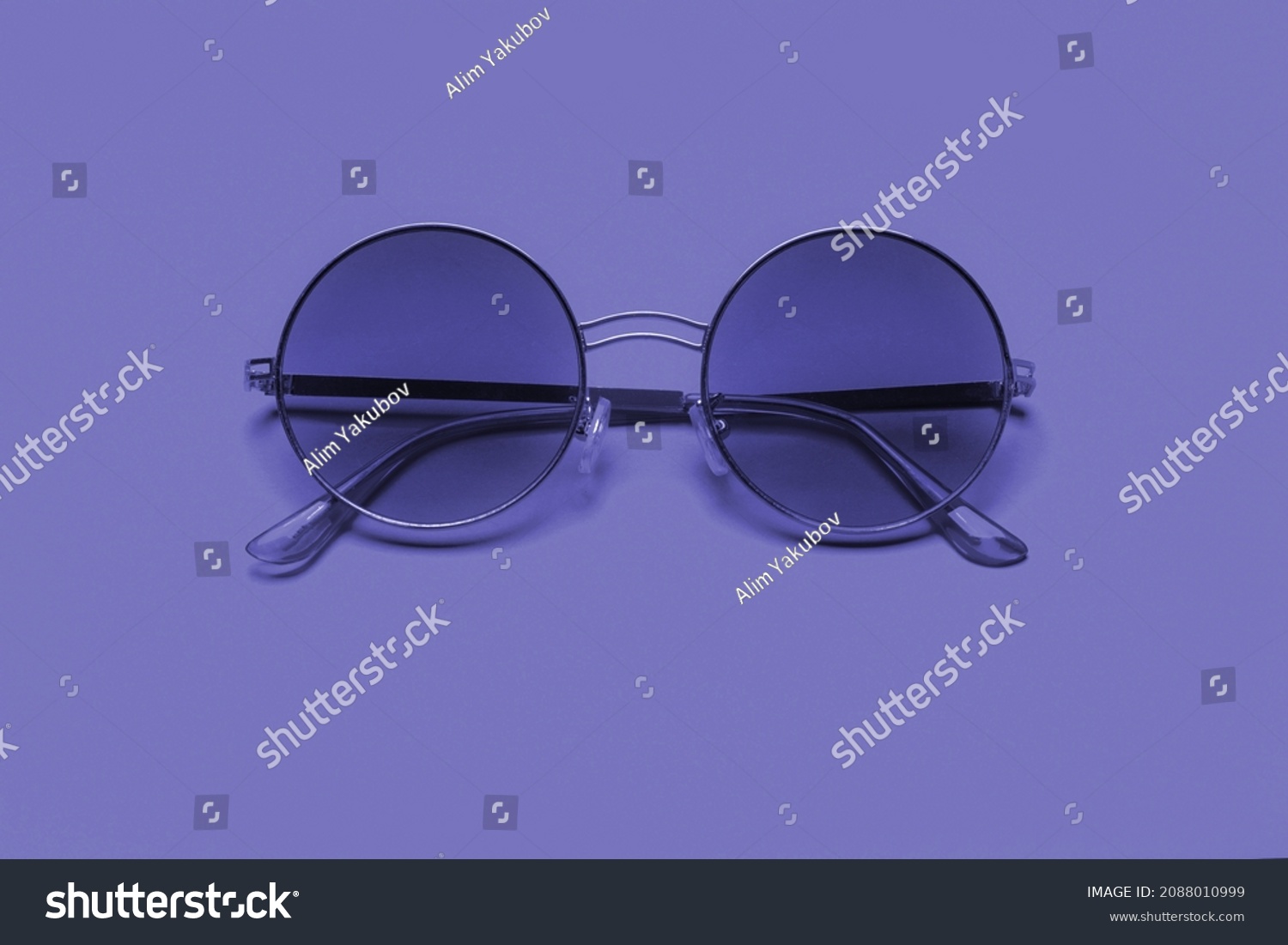 Beautiful trendy sunglasses on a pink background. New 2022 trending PANTONE 17-3938 Very Peri color
 #2088010999