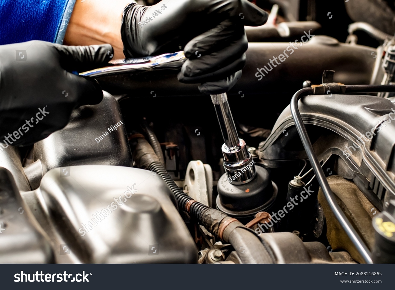 Hands with socket wrench ratchet. Changing car oil filter. DIY change engine motor oil. At home vehicle maintenance. Filter replacement. Oil filter cap #2088216865