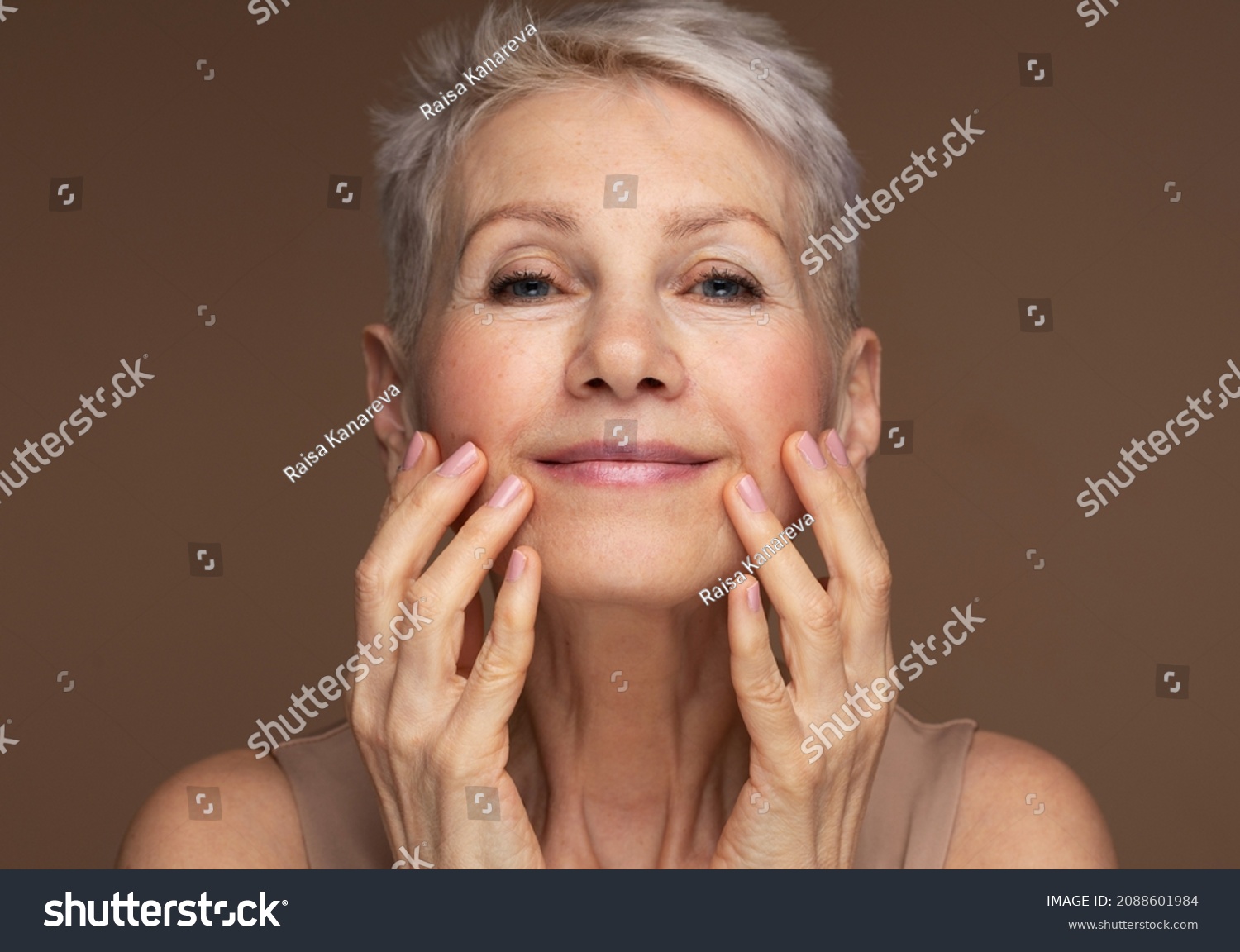 Portrait of gorgeous happy mature woman, senior older 60 year lady looking at camera touching her face #2088601984
