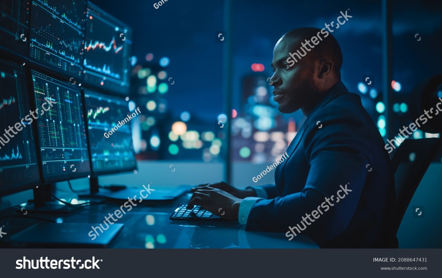 Financial Analyst Working on Computer with Multi-Monitor Workstation with Real-Time Stocks, Commodities and Exchange Market Charts. African American Trader Works in Investment Bank Late at Night. #2088647431