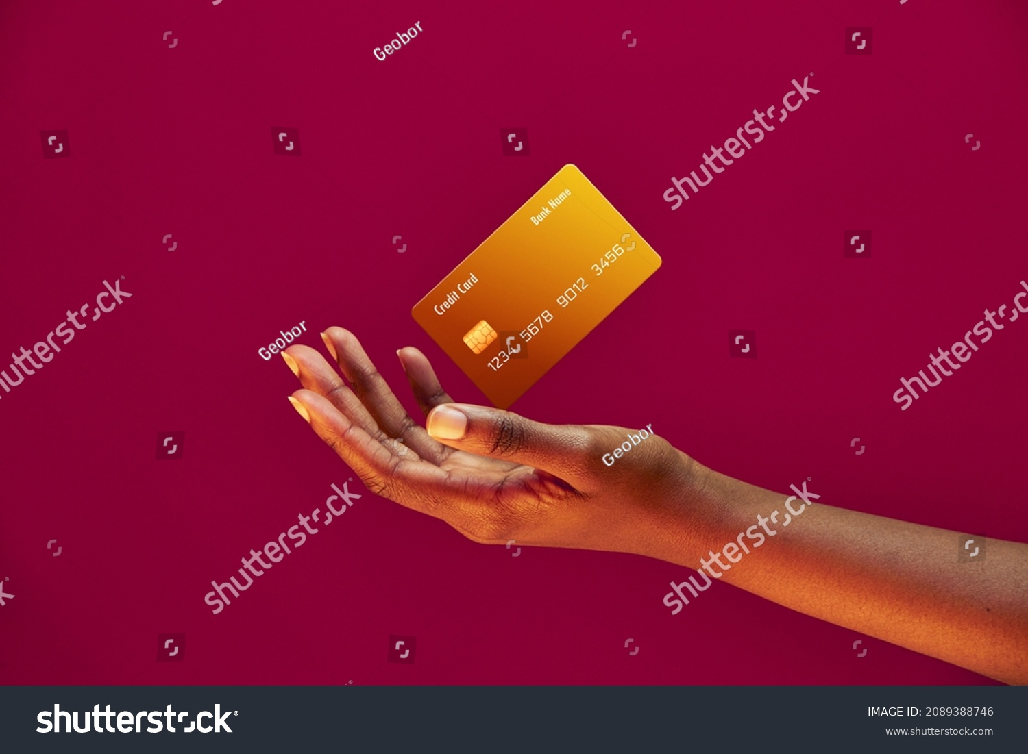 African american female hand and levitating template Bank credit card with online service on pink background #2089388746