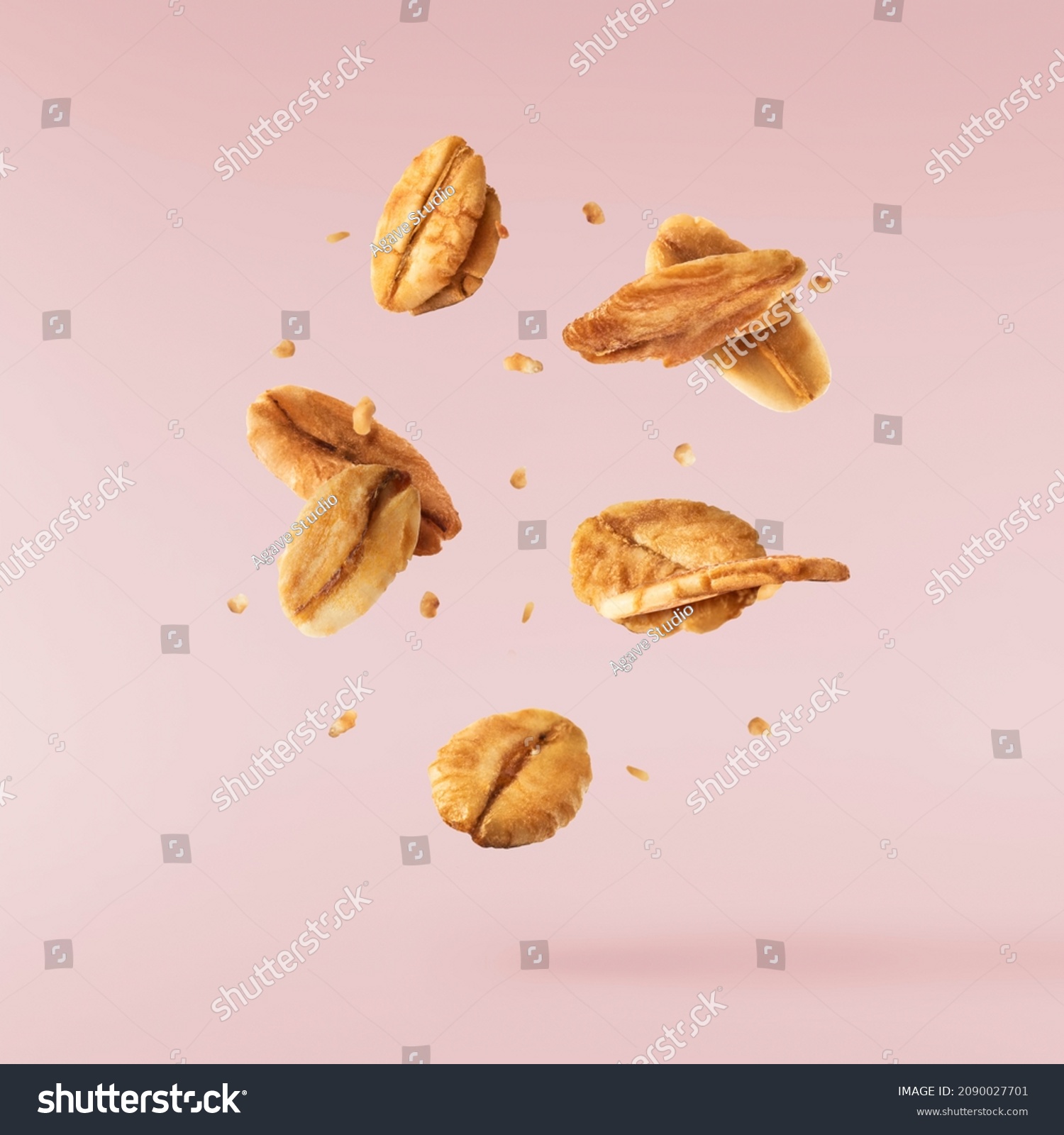 Fresh Granola flakes falling in the air on pink background. Food zero gravity conception. High resolution image #2090027701