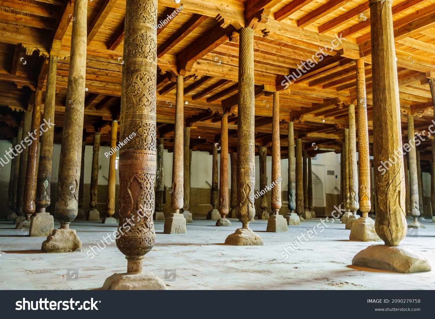 Hall with wooden columns in Juma Mosque, Khiva, Uzbekistan. Columns are unique in that they all different and don't have same design. Many columns brought from older and no longer existing mosques #2090279758