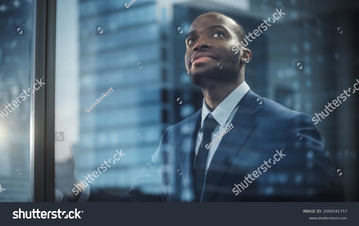 Thoughtful African-American Businessman in a Perfect Tailored Suit Standing in His Office Looking out of the Window on Big City. Successful Investment Manager Planning Strategy. Outside Shot #2090541757