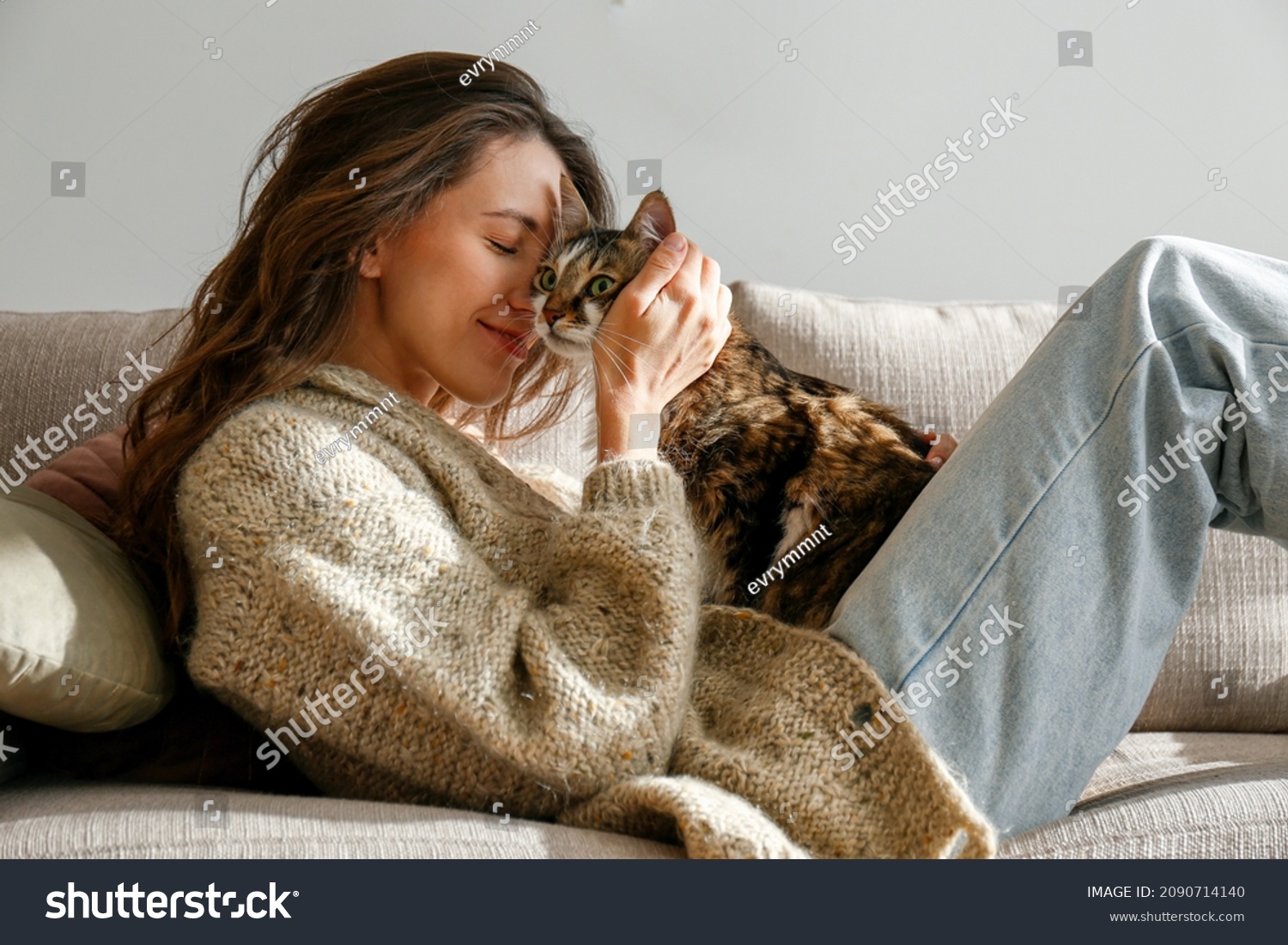 Portrait of young woman holding cute siberian cat with green eyes. Female hugging her cute long hair kitty. Background, copy space, close up. Adorable domestic pet concept. #2090714140