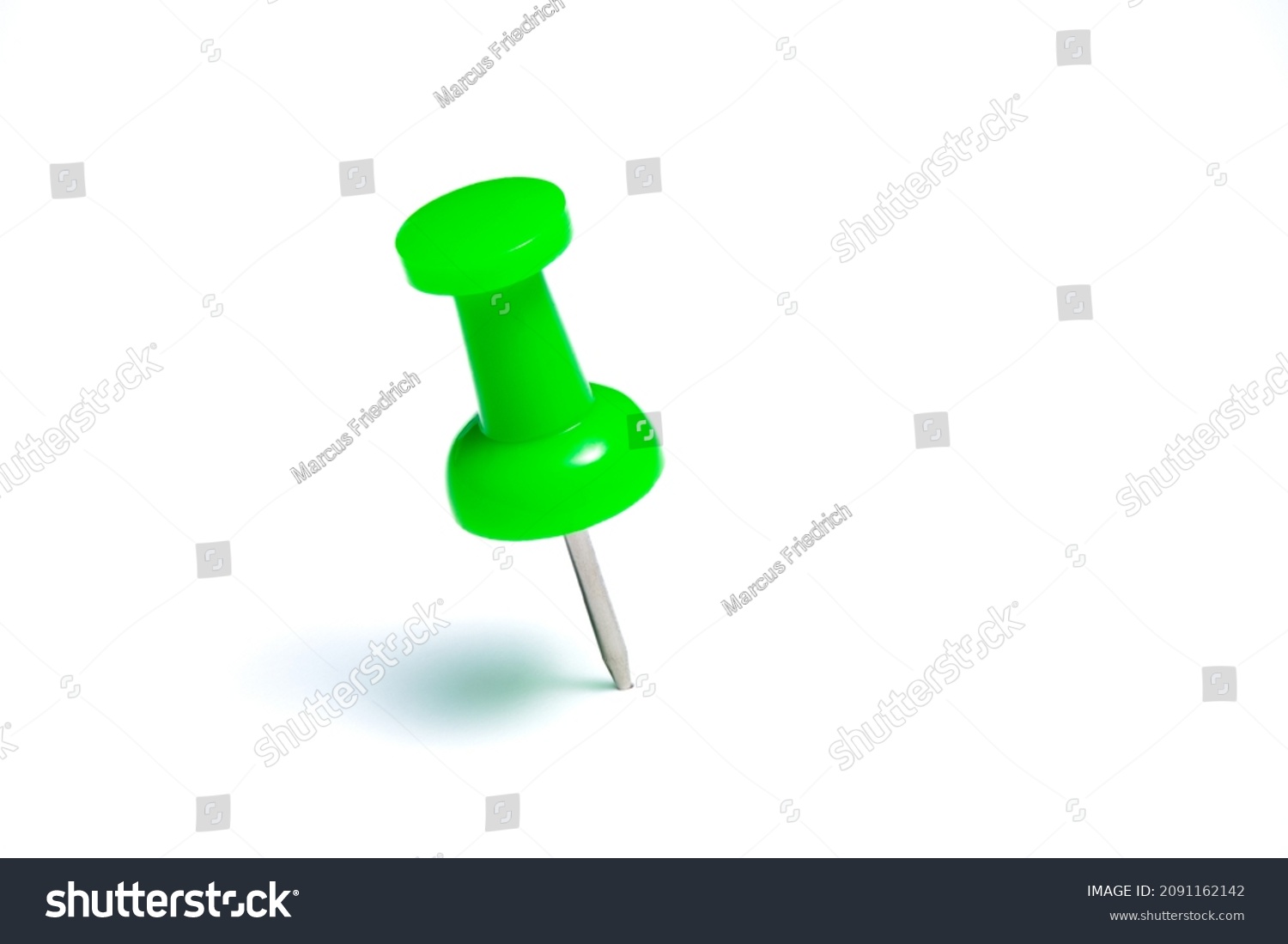 Green push pin or thumbtack isolated on a white background. #2091162142
