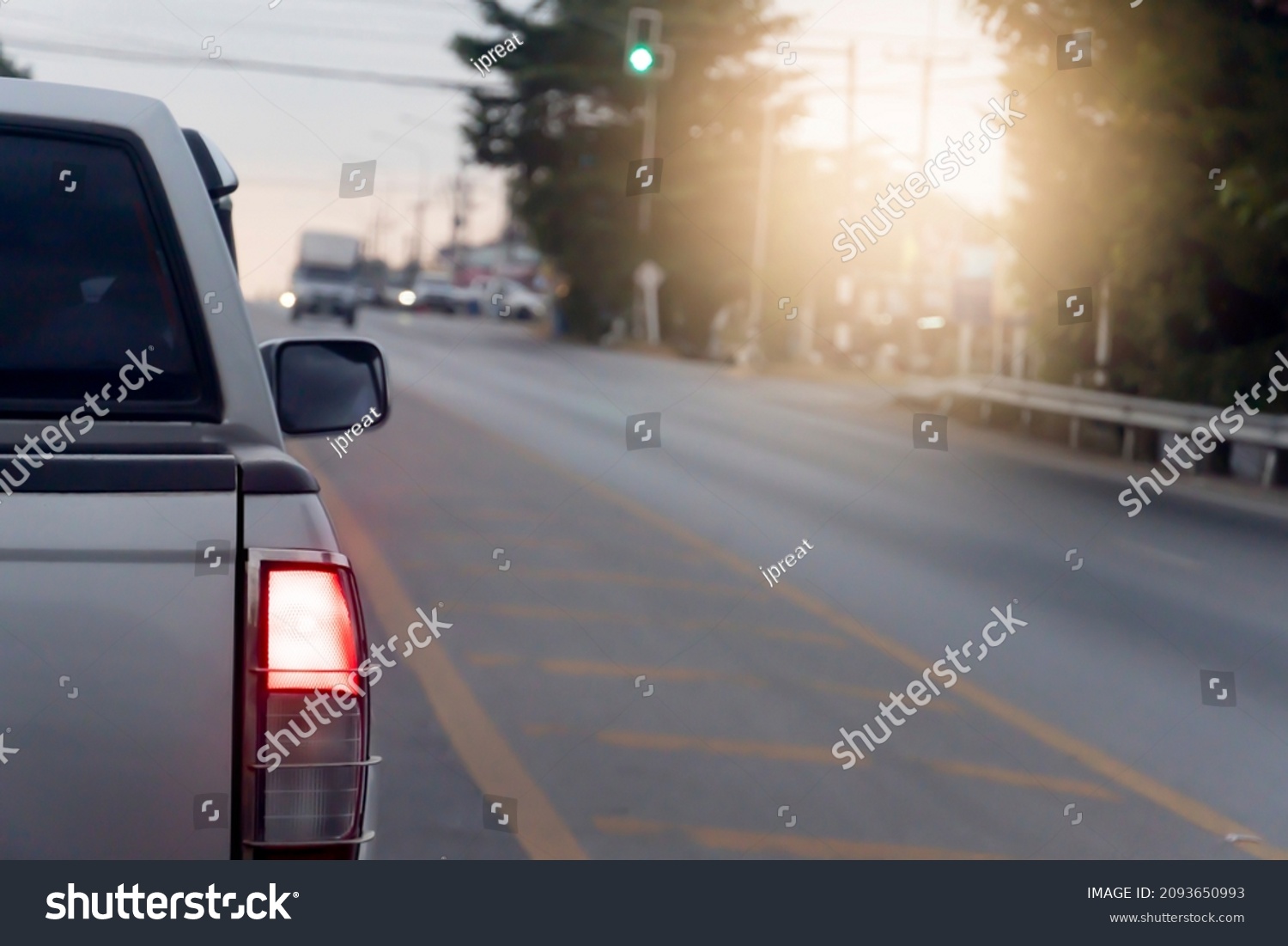 Back side of pick up car gray color on the asphalt road. With traffic conditions and hot sun during the day and other cars driving opposite lens. #2093650993