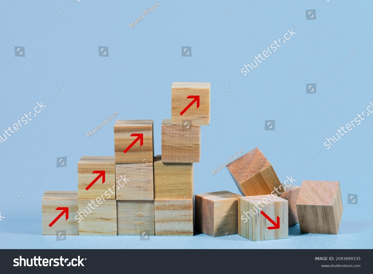 Collapsed stair structure of wooden cubes with upward pointing arrows, business risk due to inflation, crisis, supply shortage or unsustainable financial concept, blue background with copy space #2093699335