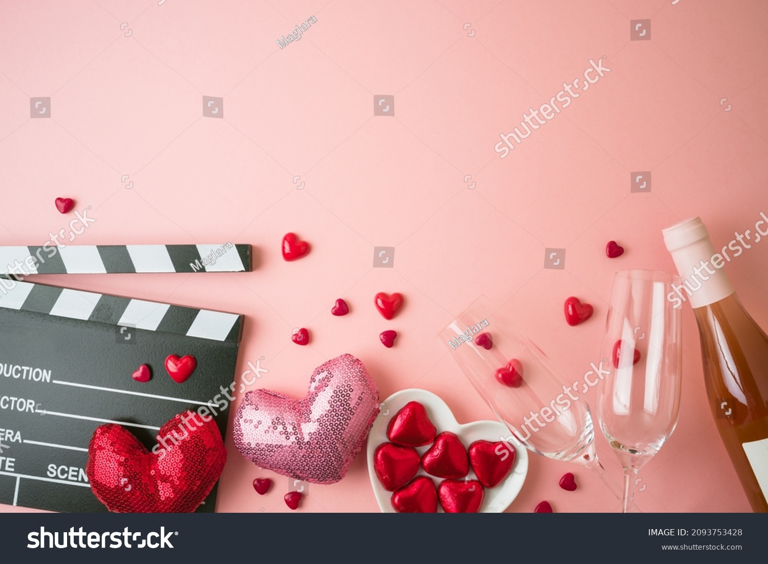 Romantic movie border frame with movie clapper board, heart shapes and wine bottle on pink background. Valentines day concept. Flat lay, top view #2093753428