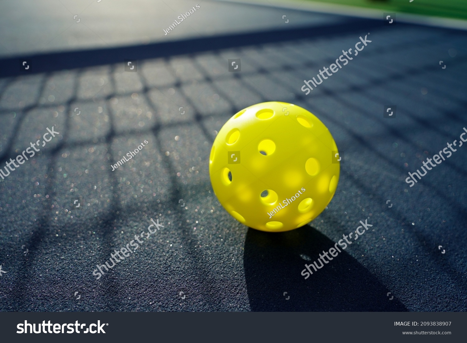 Close up of a pickleball on a pickleball court.                         #2093838907