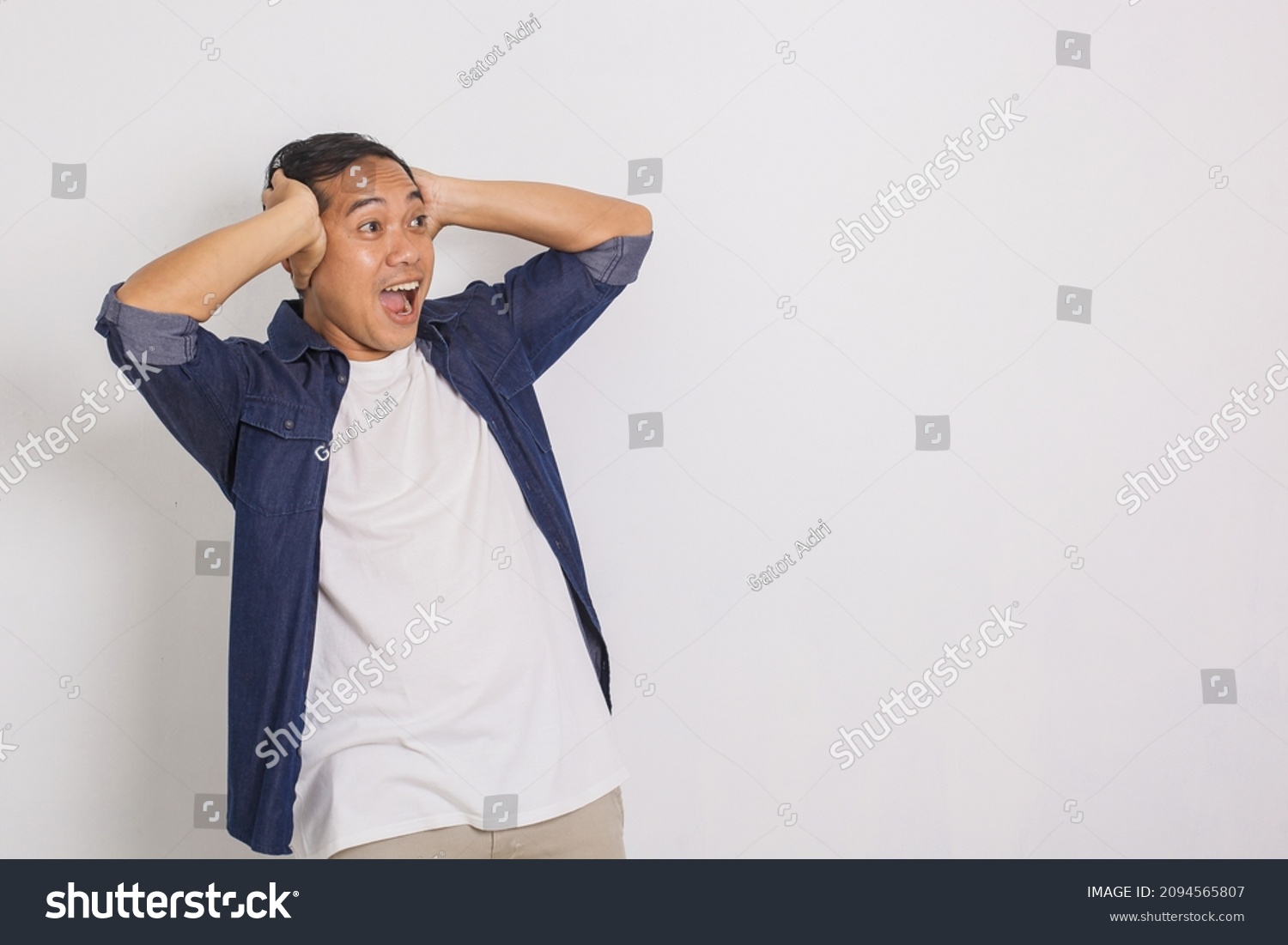 Portrait of surprised asian man, shouting, shocked, looking at copy space beside isolated on white background #2094565807