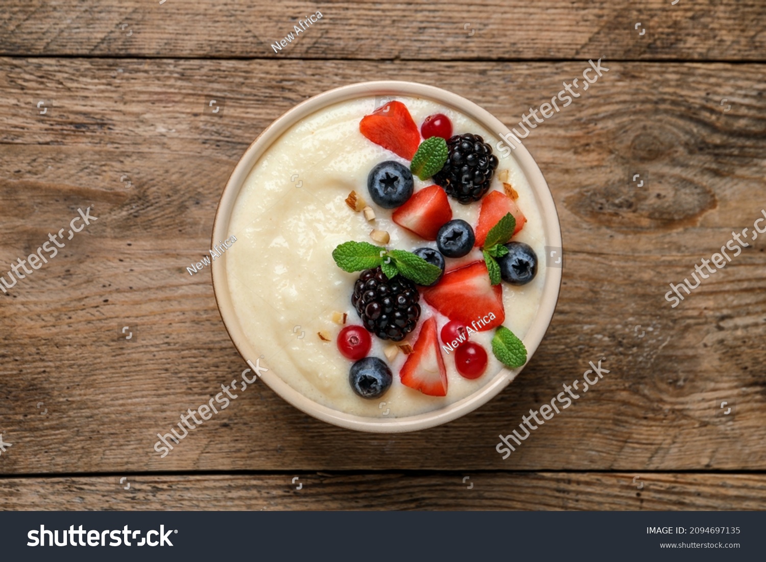 Delicious semolina pudding with berries on wooden table, top view #2094697135