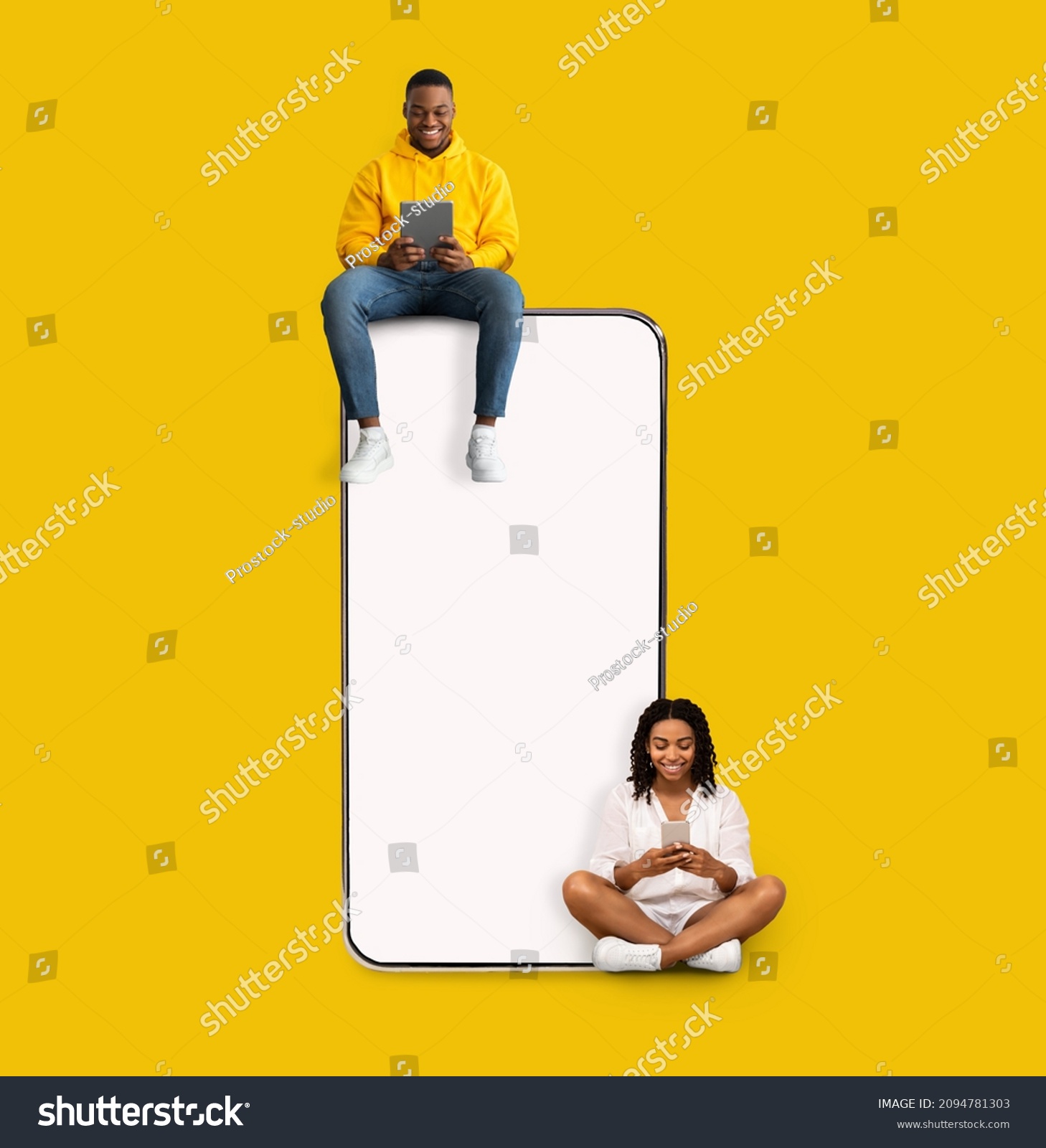 Great App. Excited Black Couple Sitting On Big Smartphone With Blank White Screen Using Gadgets, Cheerful Guy And Lady Chatting On Social Media, Yellow Orange Wall, Mock Up. Modern Communication #2094781303