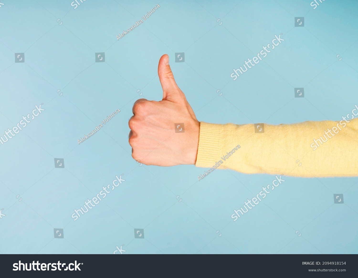 Thump up hand sign isolated on blue background. Copy space for your text #2094918154