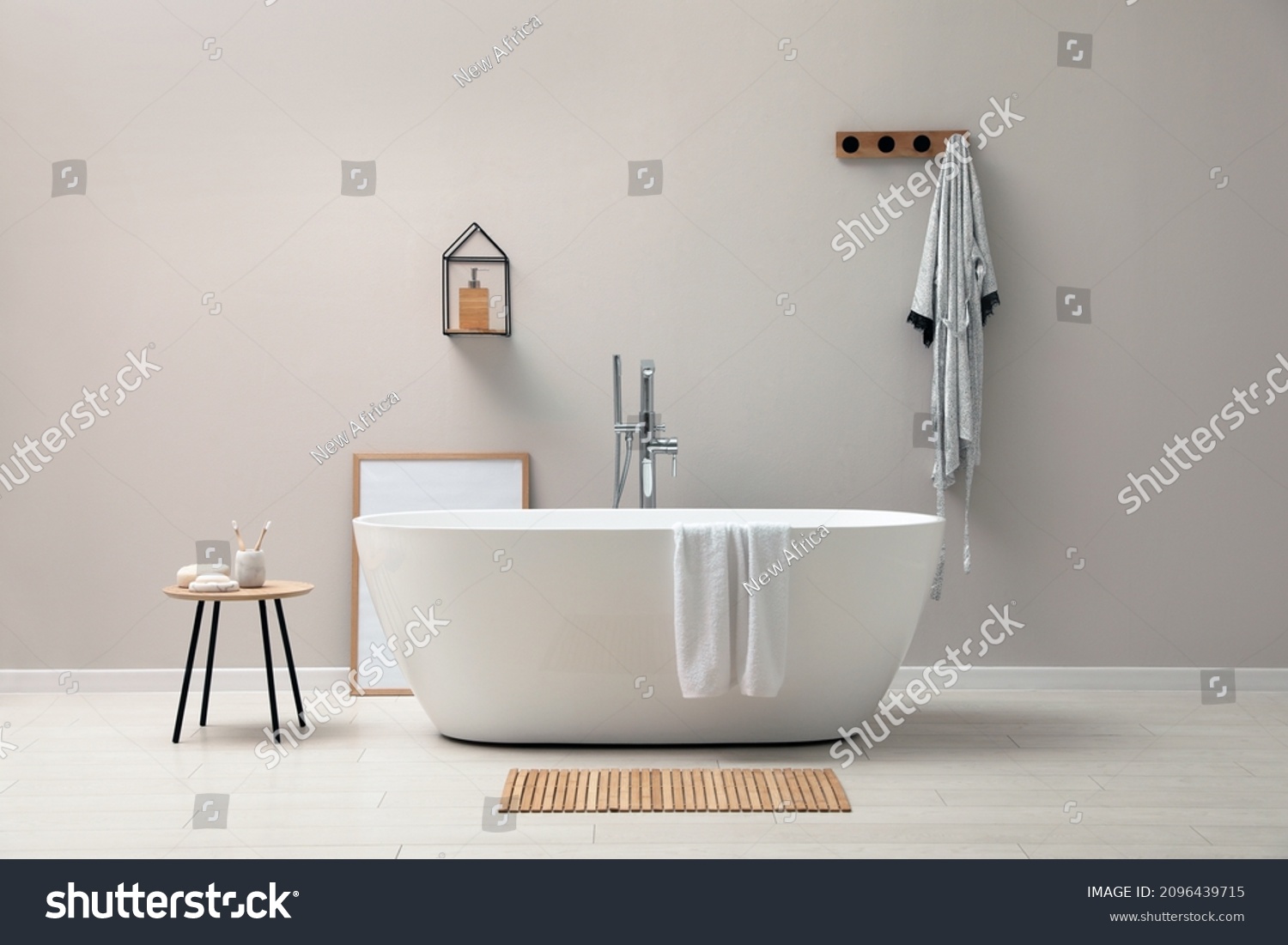 Modern ceramic bathtub near light wall indoors #2096439715