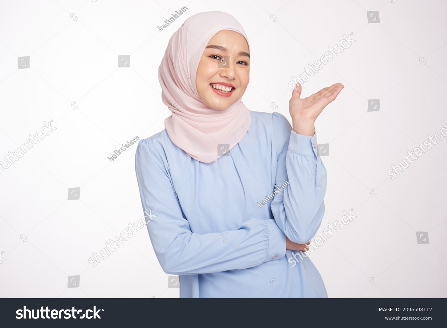 Beautiful asian muslim woman with hands showing and presenting something in the direction of empty space for presenting something and presenting product. #2096598112