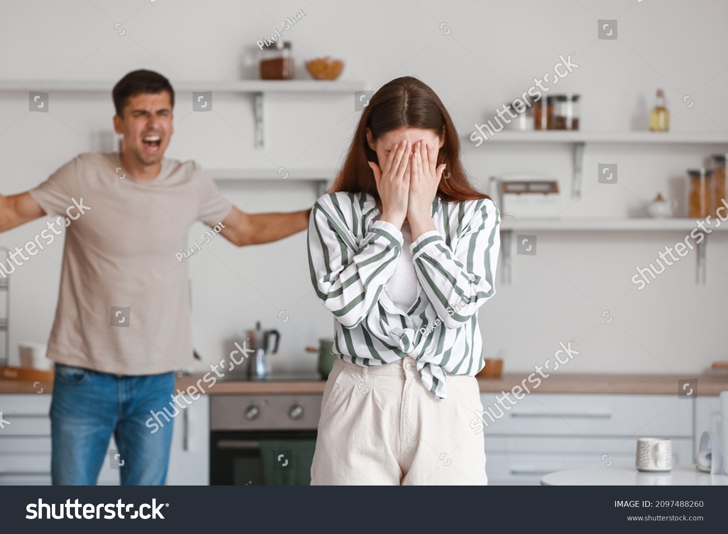 Upset young woman during quarreling with her husband in kitchen #2097488260