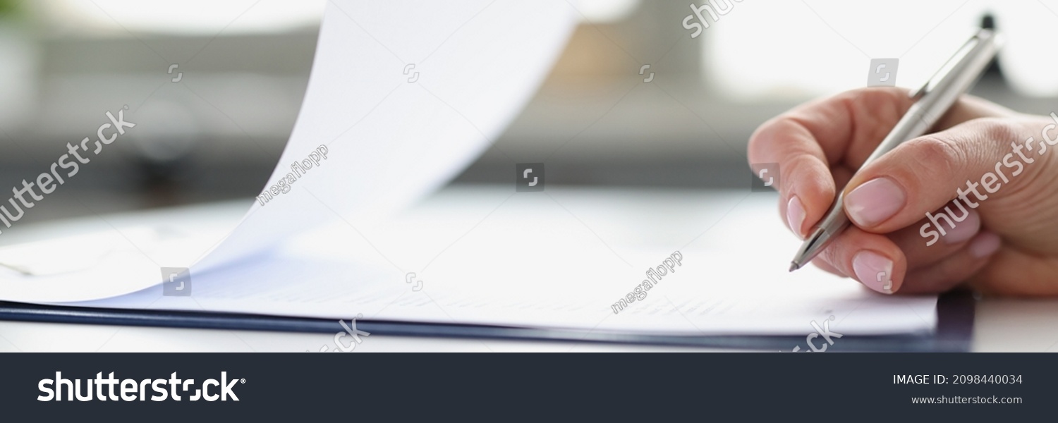 Woman hand signing documents on clipboard with ballpoint pen closeup. Conclusion of contracts and transactions concept #2098440034