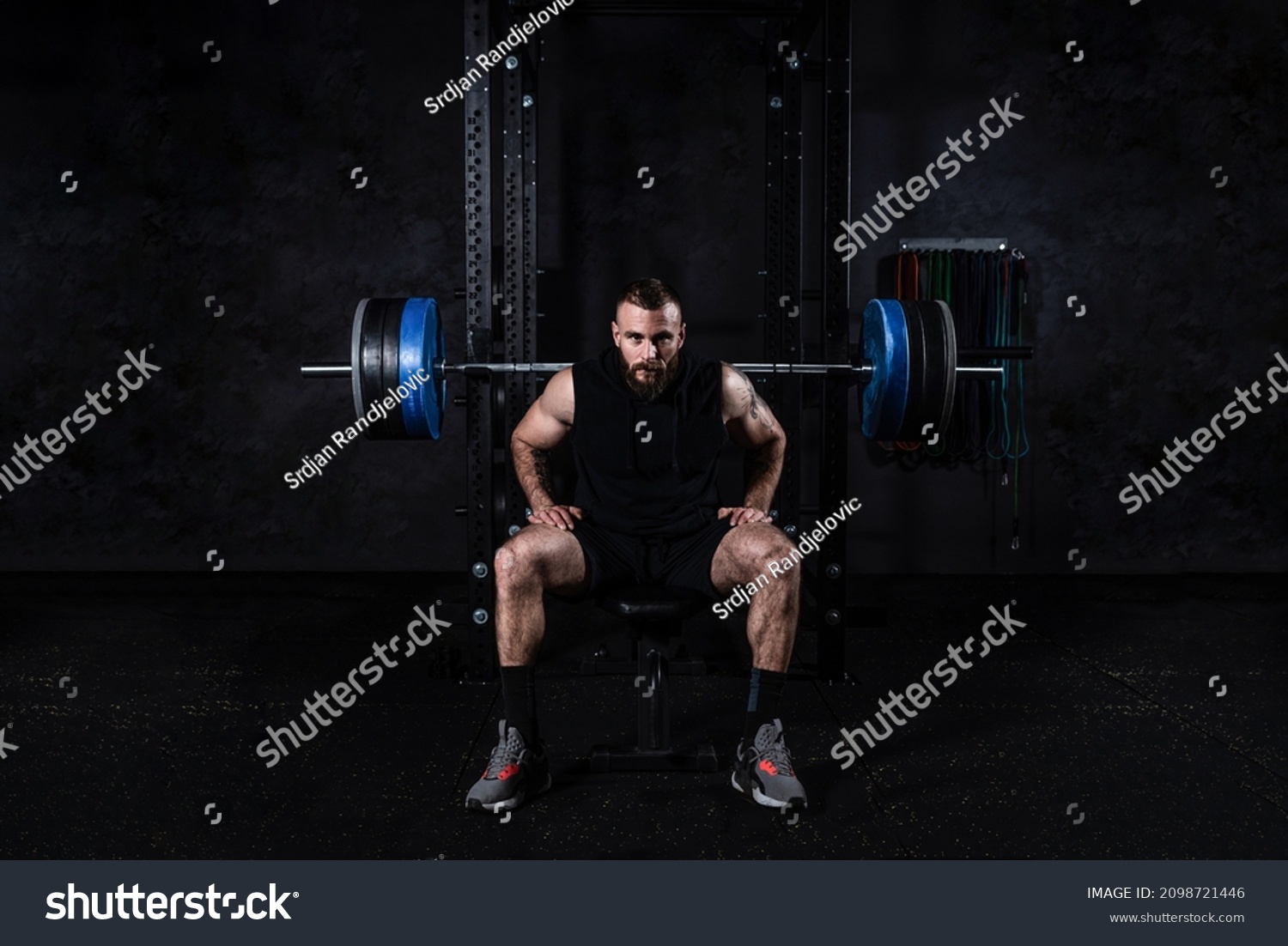 Young active strong sweaty muscular fit man with big muscles preparing for hardcore benchpress workout cross training with heavy barbell weights in the gym. Male concentrated sitting on the bench. #2098721446