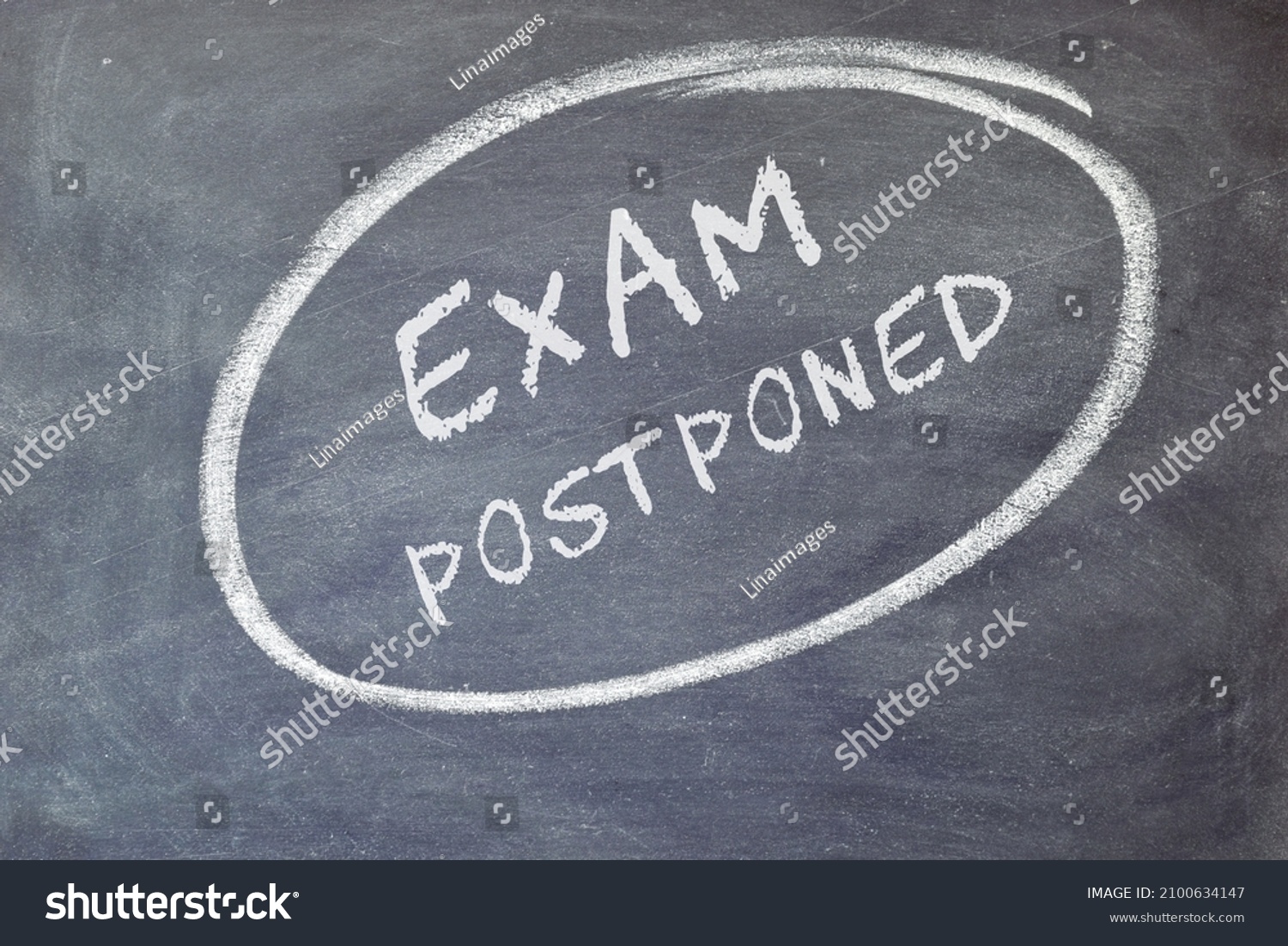 EXAM postponed text on blackboard background.  #2100634147