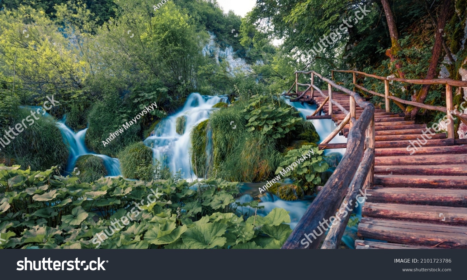 Wooden footbridge in Plitvice National Park. Fresh green scene of summer forest with pure water waterfall. Beautiful countryside landscape of Croatia, Europe. Beauty of nature concept background. #2101723786