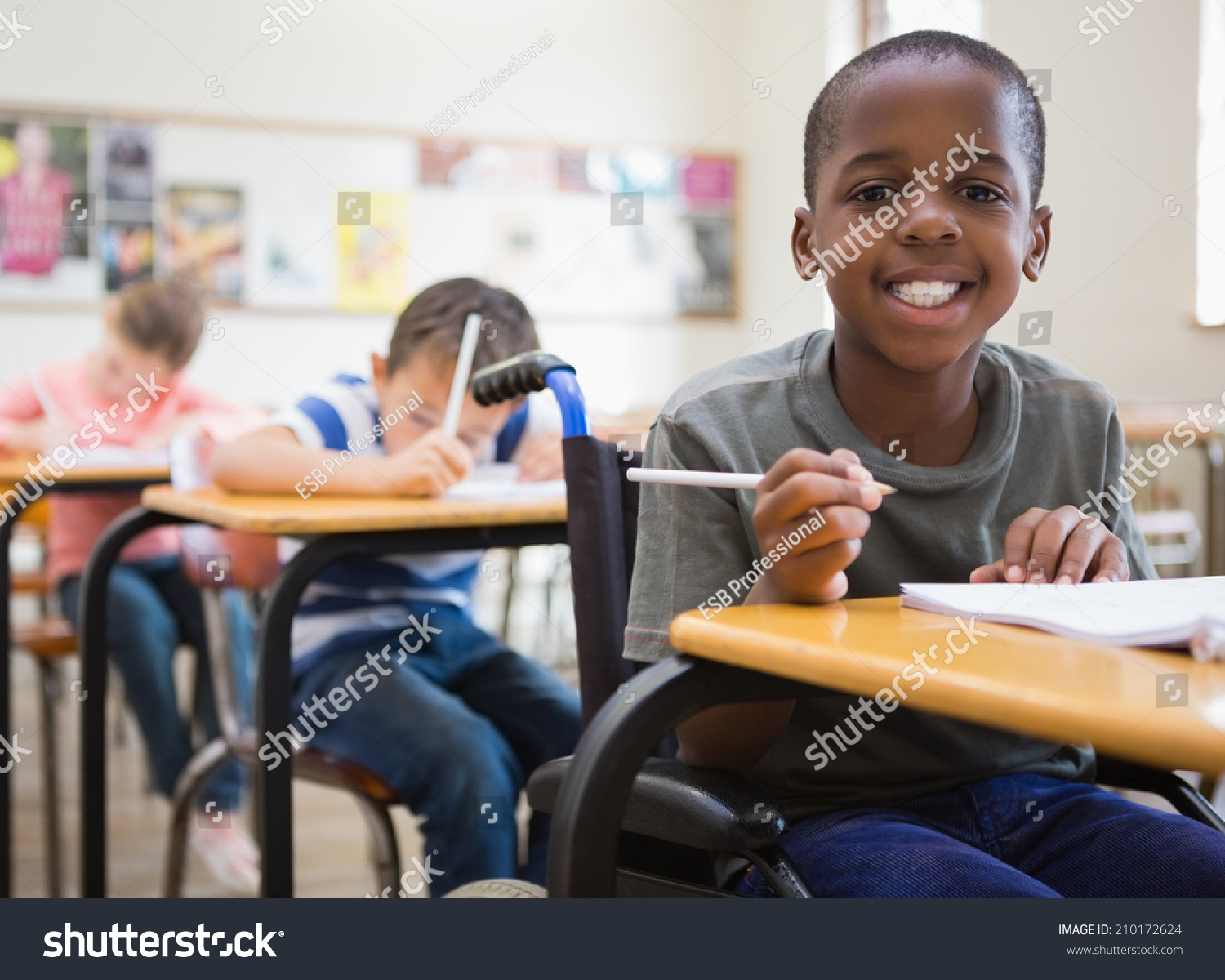 Disabled pupil smiling at camera in classroom at the elementary school #210172624