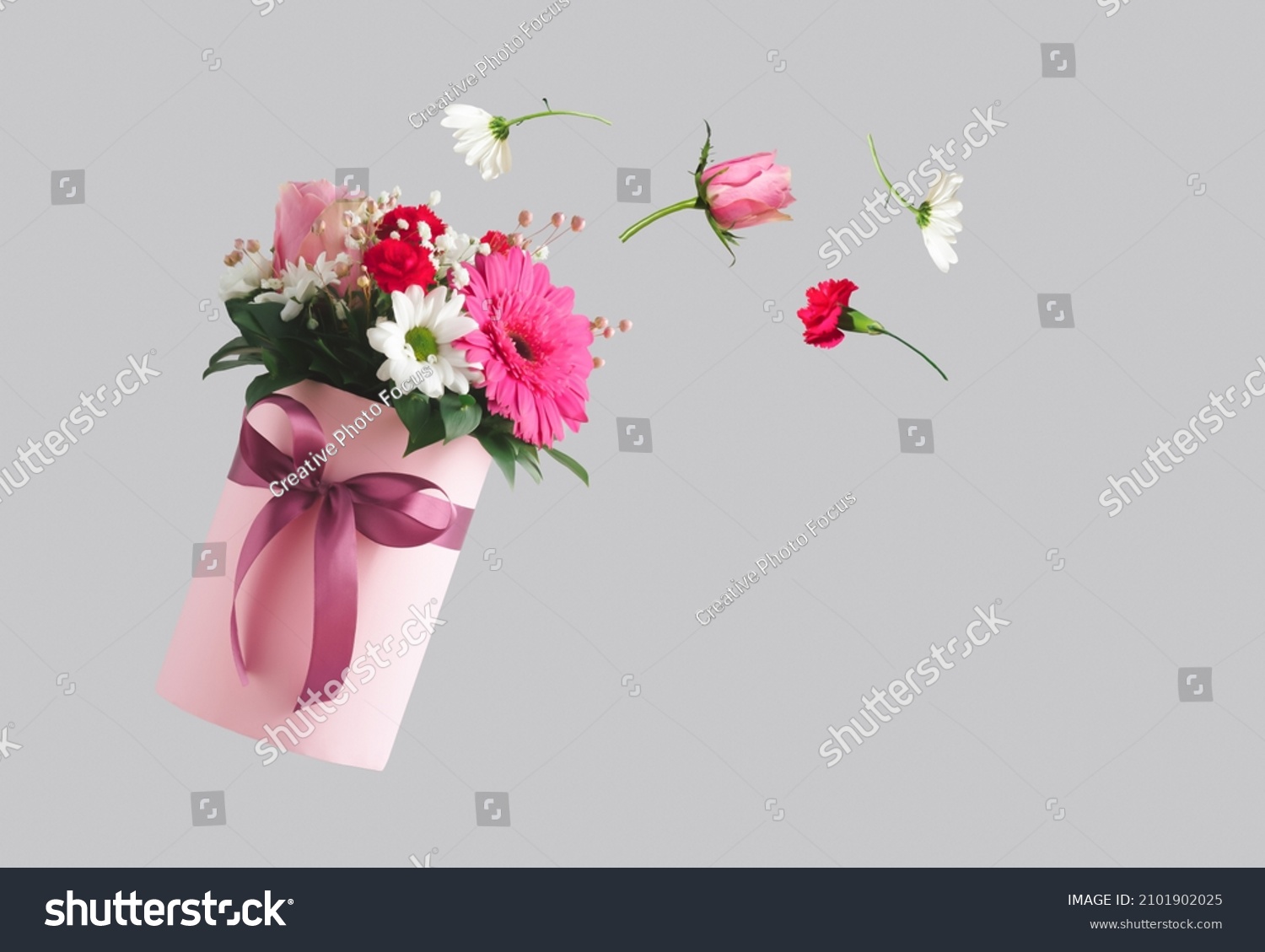 Pink gift box with various flowers on grey background. Flying flowers from the box. Valentines day aesthetic nature concept. 8 March card idea. #2101902025
