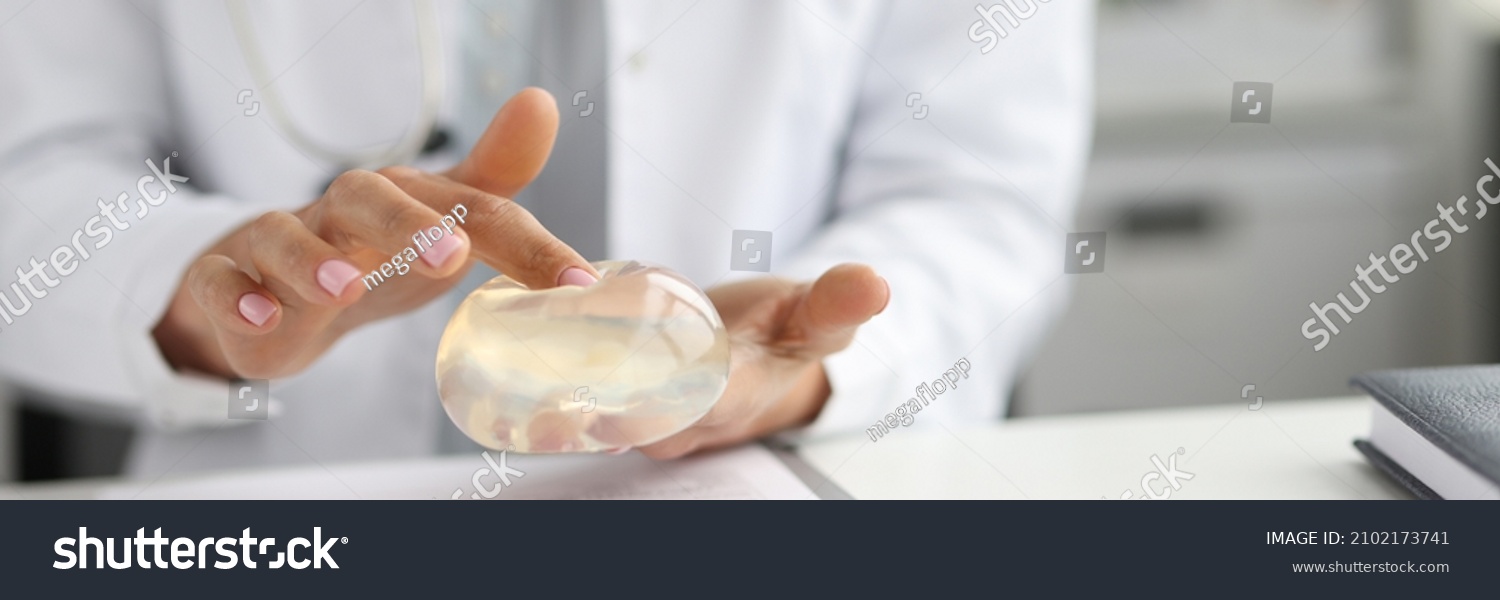 Doctor surgeon holding breast silicone implant in clinic. Breast enlargement surgery concept #2102173741