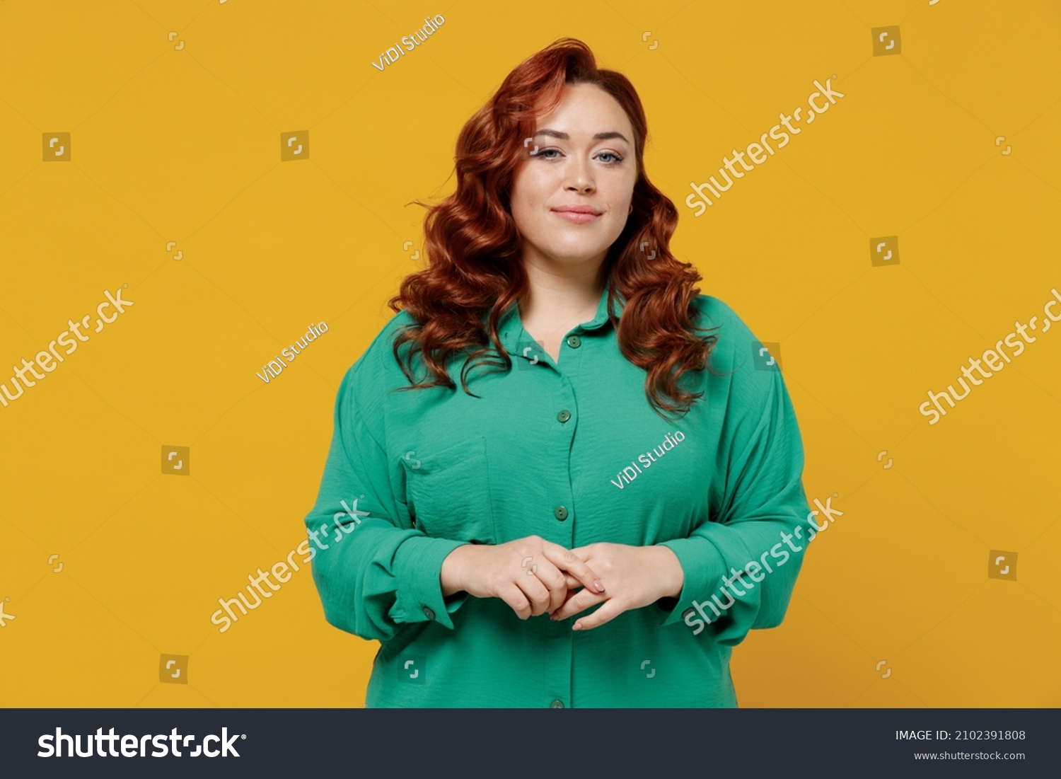 Charming bright happy young ginger chubby overweight woman 20s years old wears green shirt looking camera smiling isolated on plain yellow background studio portrait. People emotions lifestyle concept #2102391808