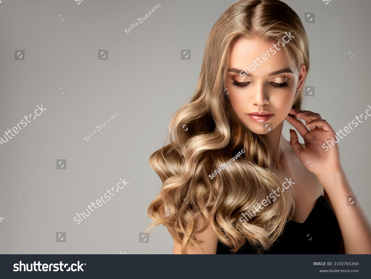 Blonde girl with long  and   shiny wavy hair .  Beautiful  woman model with curly hairstyle . #2102765260