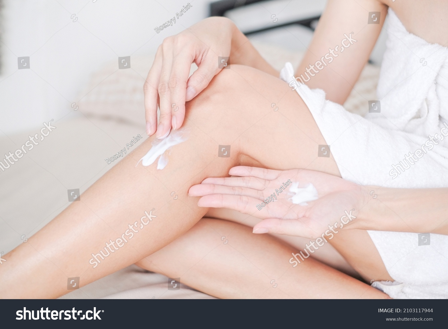 Woman applying cream,lotion on leg with white background, Beauty concept. #2103117944