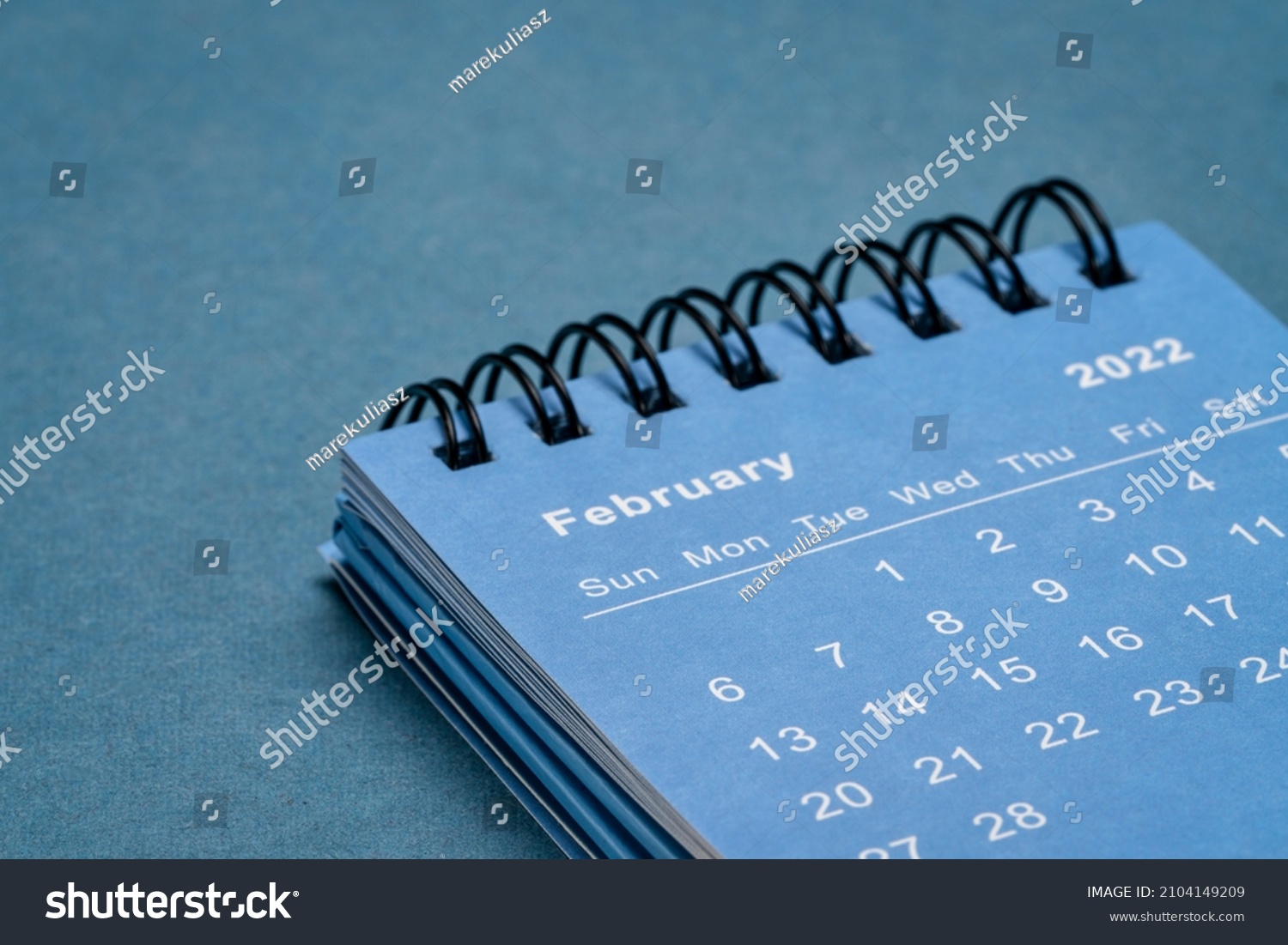 February 2022 - spiral desktop calendar against textured paper, time and business concept #2104149209