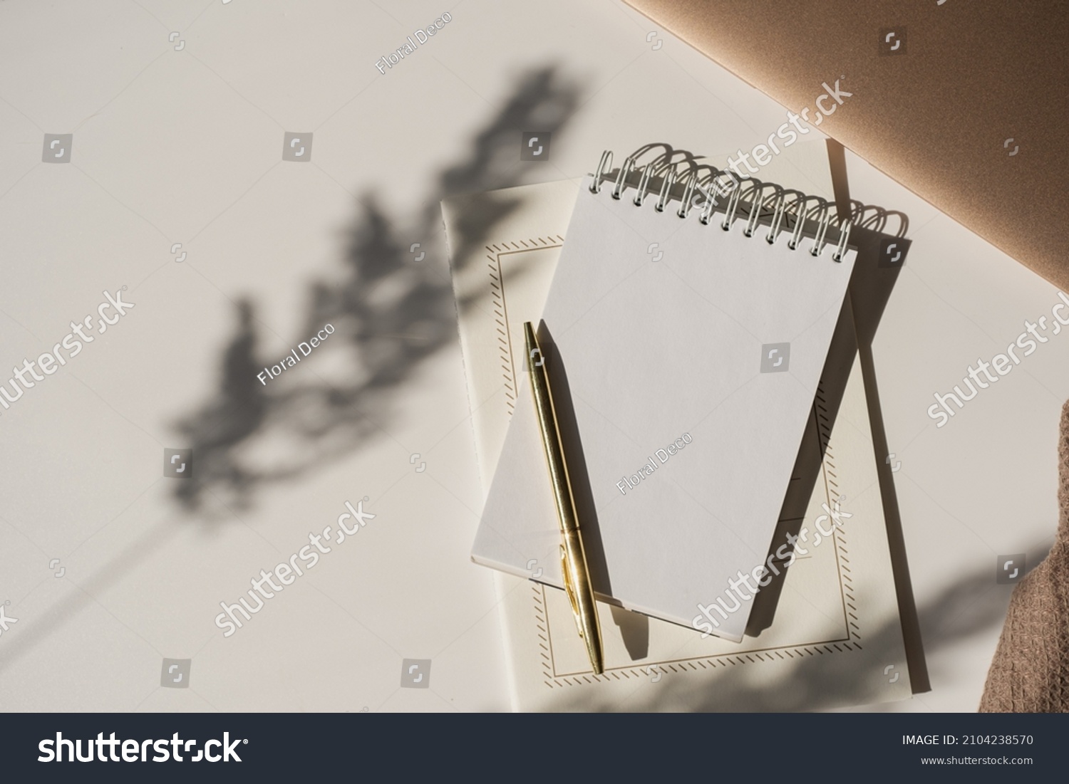 Aesthetic luxury workspace template. Spiral flip notebook with copy space in plant sunlight shadow on white background. Schedule, notes concept for blog, social media, web #2104238570