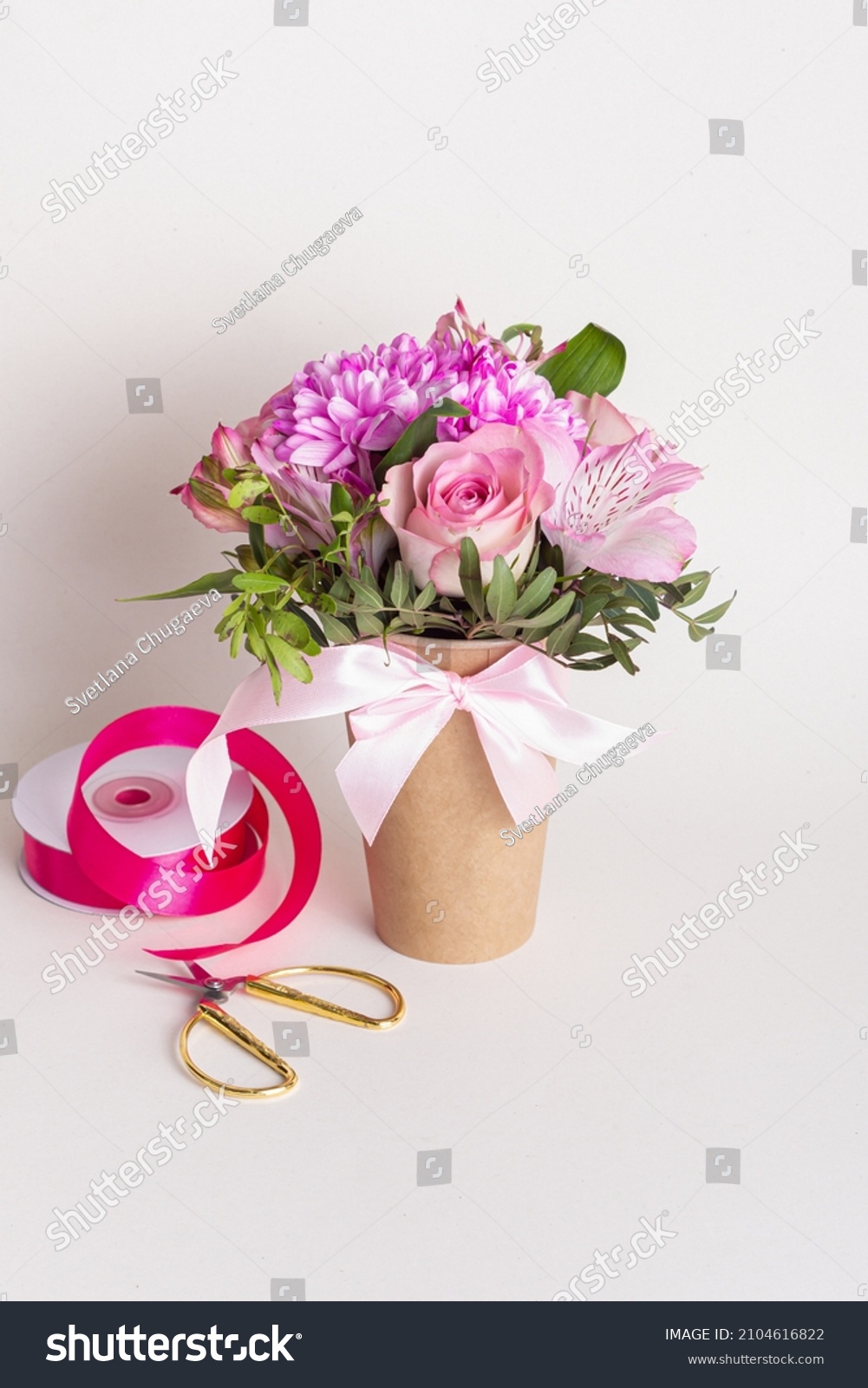Delicate floral arrangement in paper cup. Gift for Woman's Day or Valentine's Day. Pink roses and chrysanthemums #2104616822