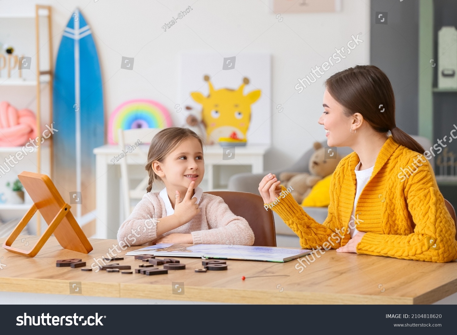 Speech therapist working with cute girl in clinic #2104818620