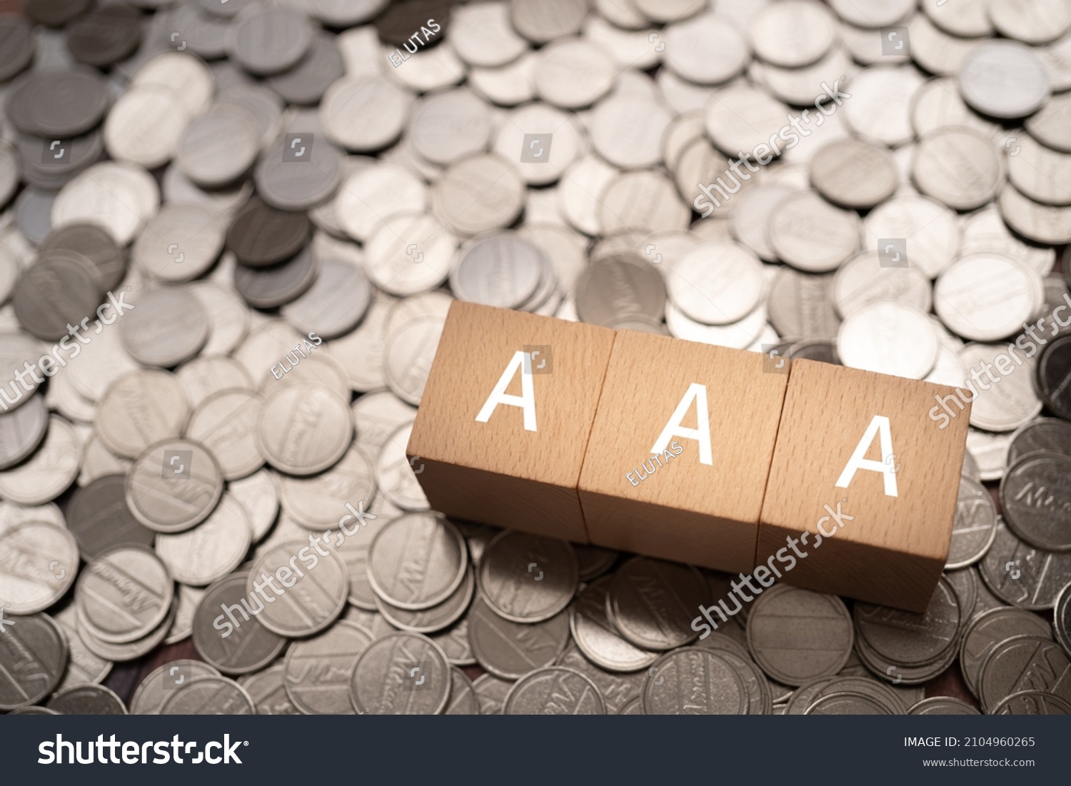 Wooden blocks with "AAA" text of concept and coins. #2104960265
