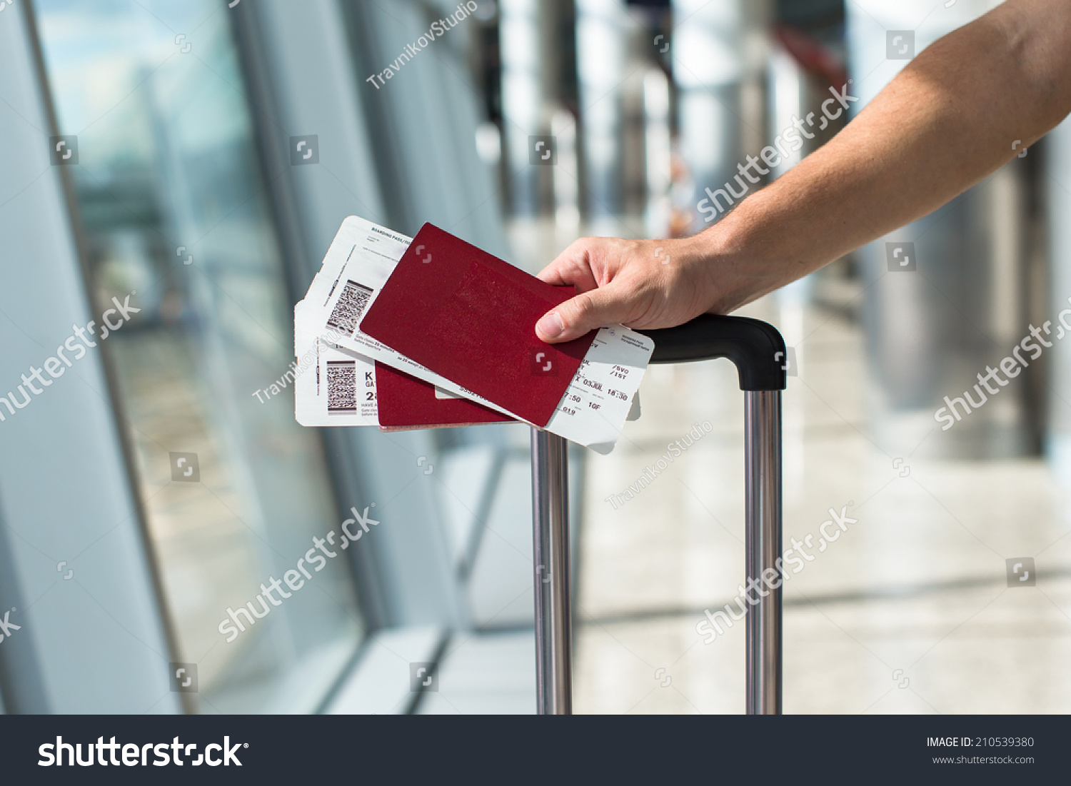 Closeup of man holding passports and boarding pass at airport #210539380