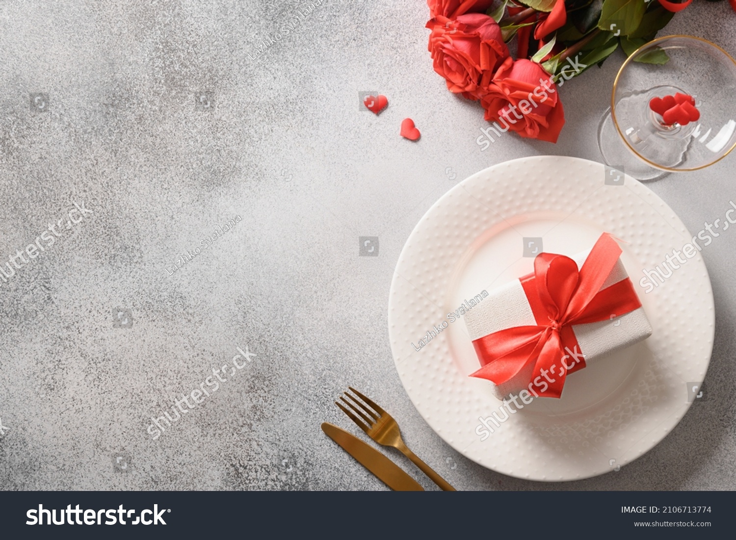 Valentine's day dinner with red roses, romantic gift and red roses on gray background. View from above. Copy space. #2106713774