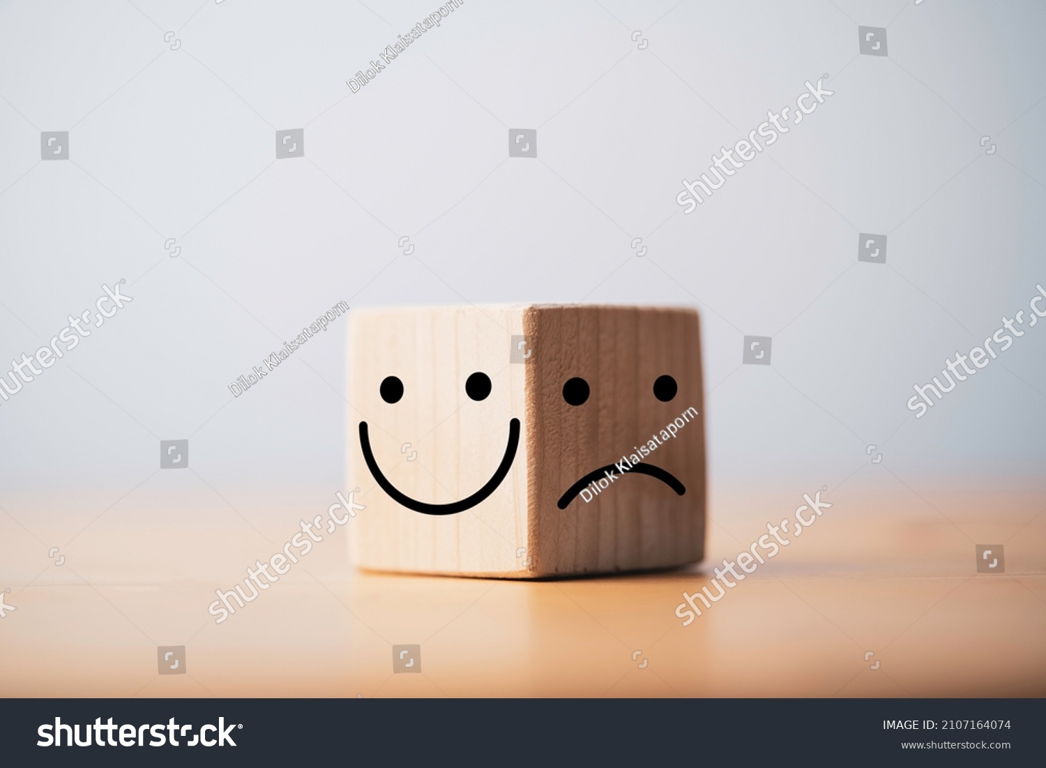 Smile face in bright side and sad face in dark side on wooden block cube for positive mindset selection concept. #2107164074