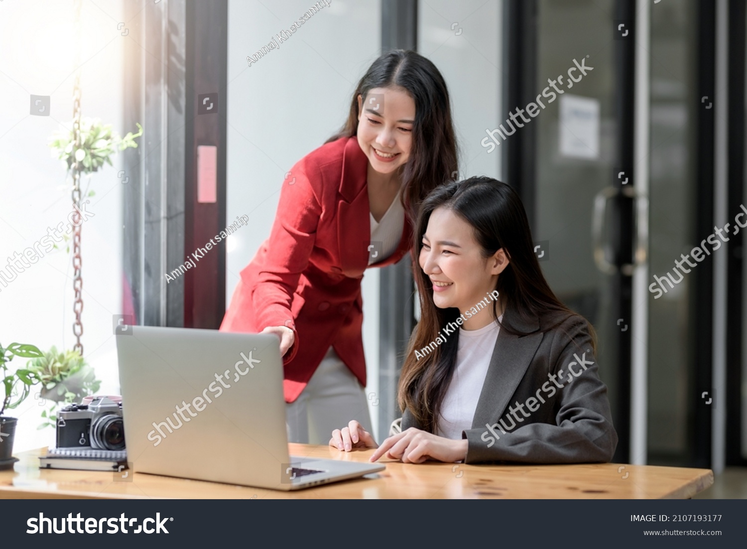 Two Young Asian businesswoman discuss with new startup project Idea presentation, analyze planning and financial statistics and investment market at office. #2107193177