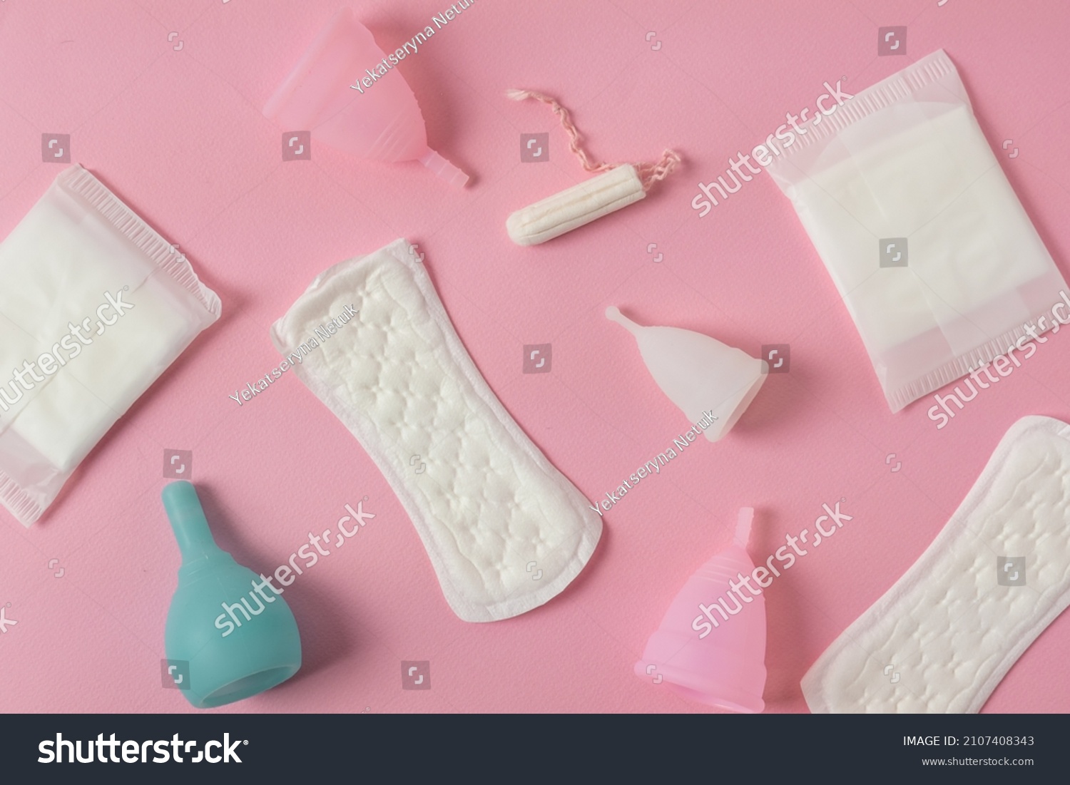 Different types of feminine menstrual hygiene materials products such as pads cloths tampons and cups. Pink background. Menstruation and feminine hygiene concept. #2107408343